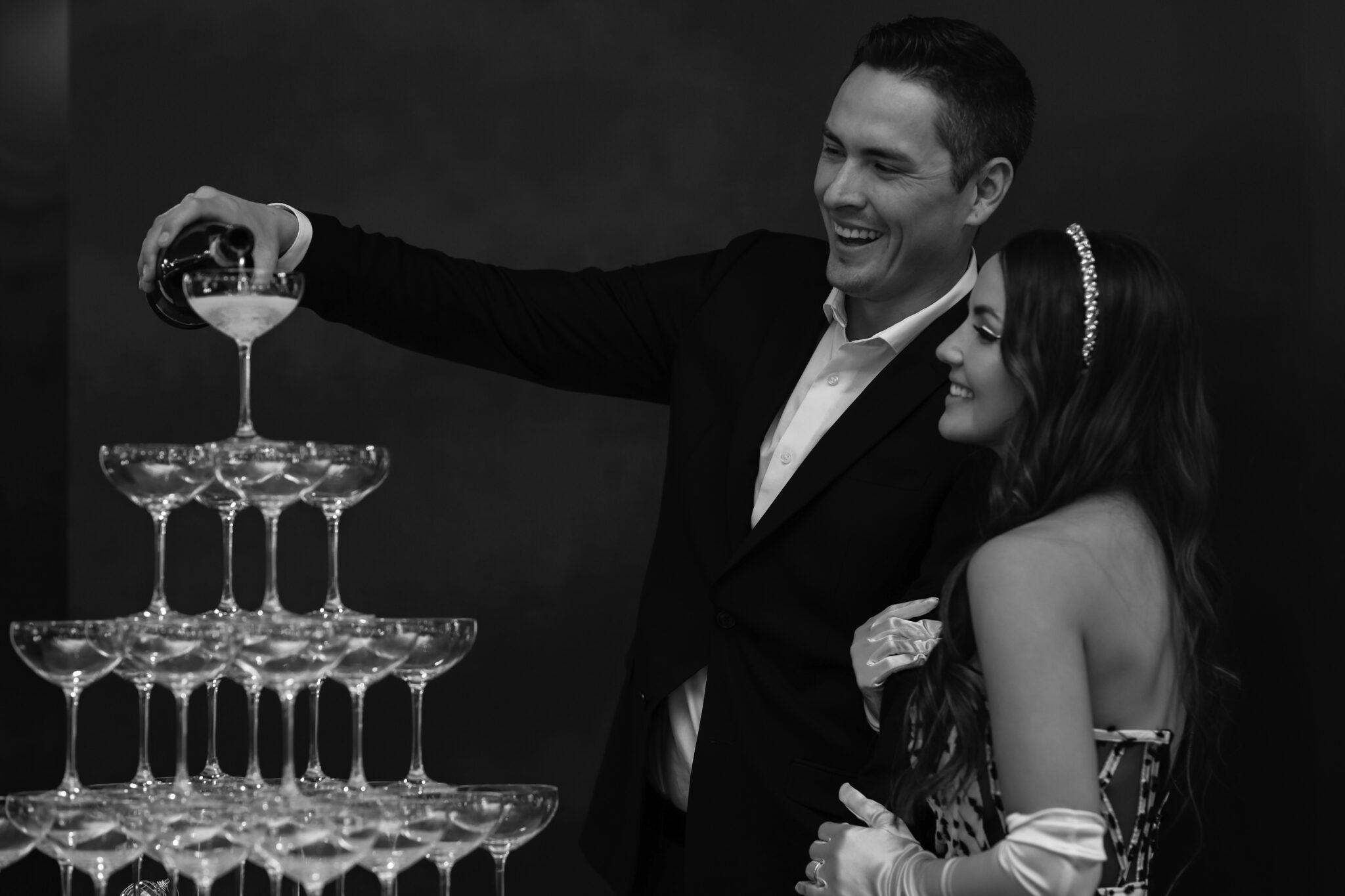 Bride and groom pouring champagne tower at retro-inspired wedding at The Brownstone in Calgary, Alberta.