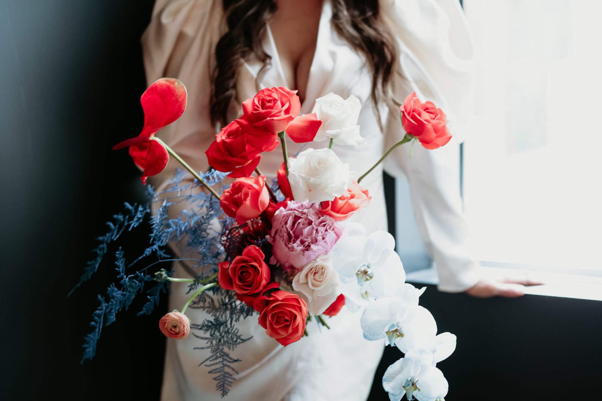 Chic stylish bride holding bold florals by The Series By Court, blending modern and retro styles with eye-catching accents.