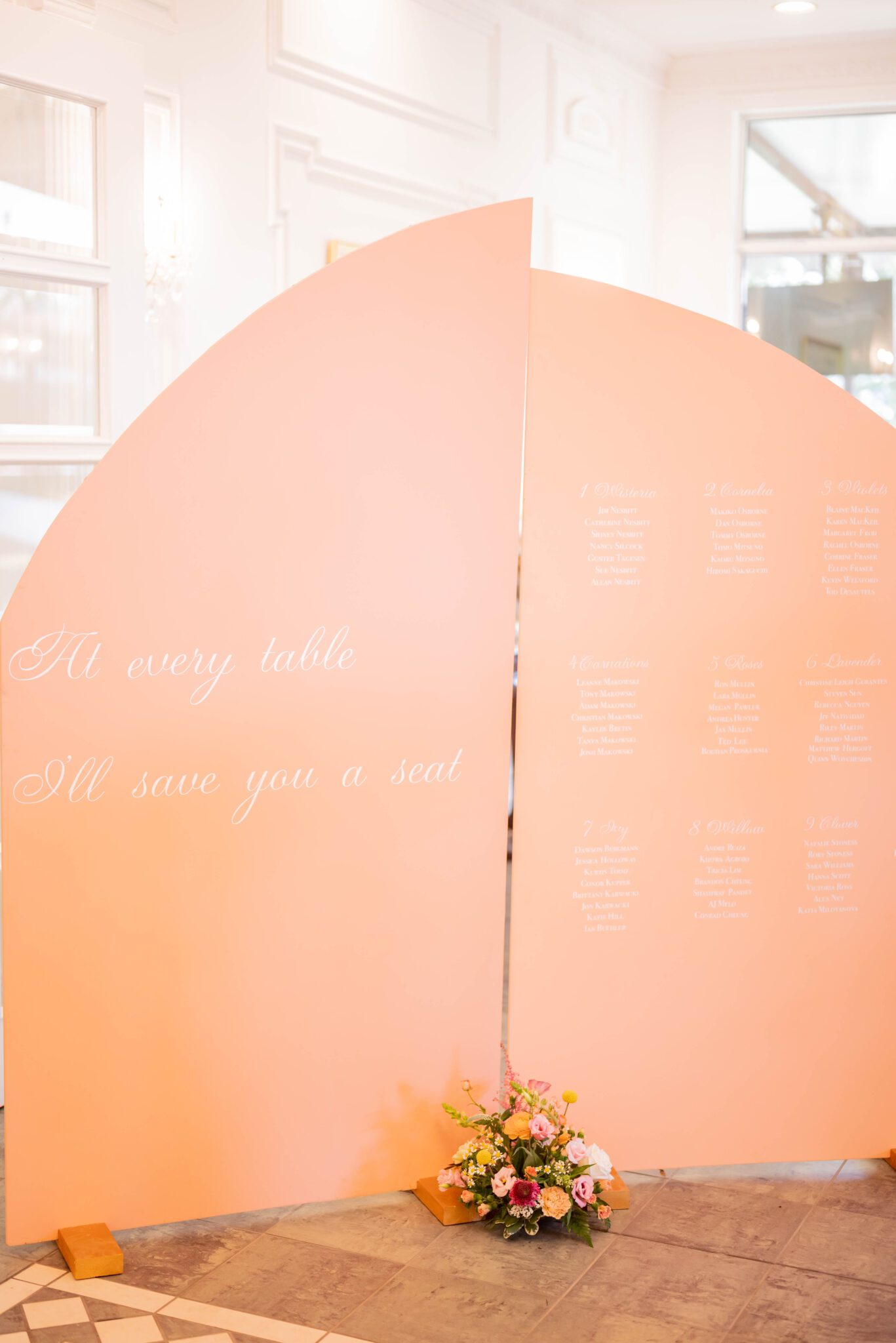Peach-coloured welcome signage at a whimsical garden party wedding at Spruce Meadows.