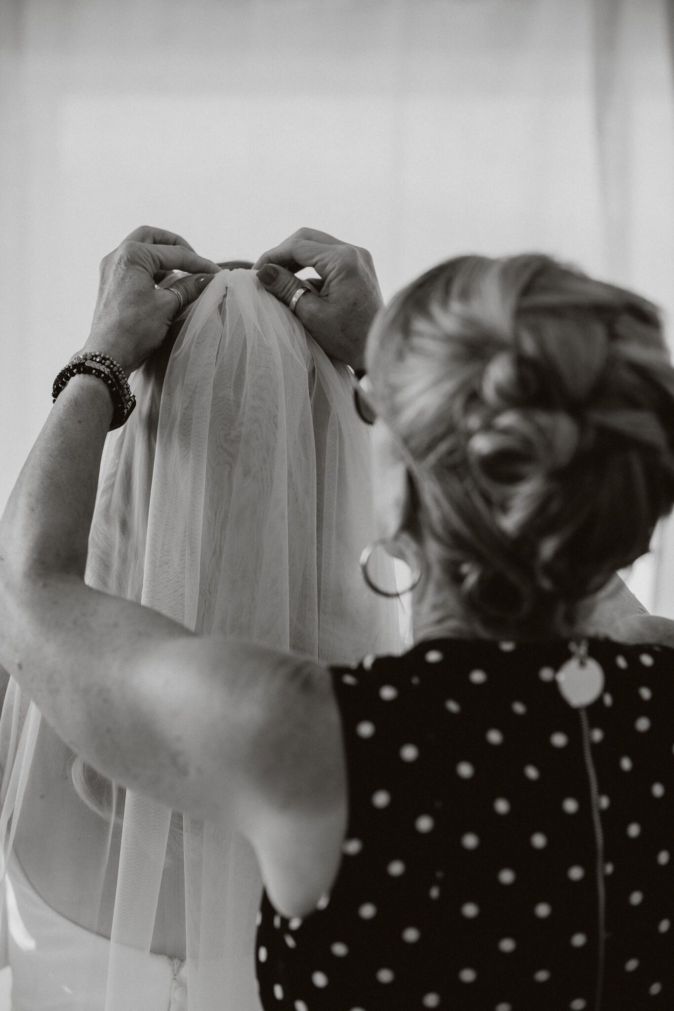 Mother of bride helping to place veil in bride's hair, black and white portrait inspiration. 