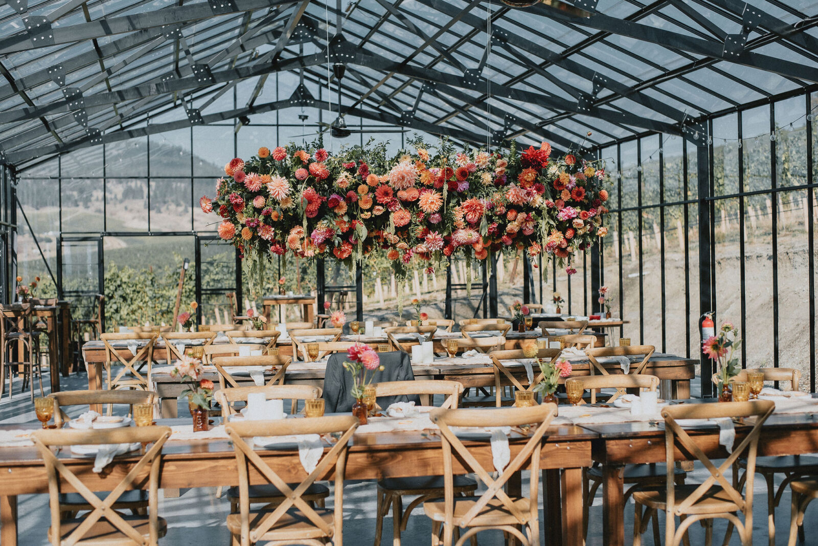 Floral filled and colourful intimate reception space located on an Okanagan vineyard, featuring colourful hanging floral installation. 