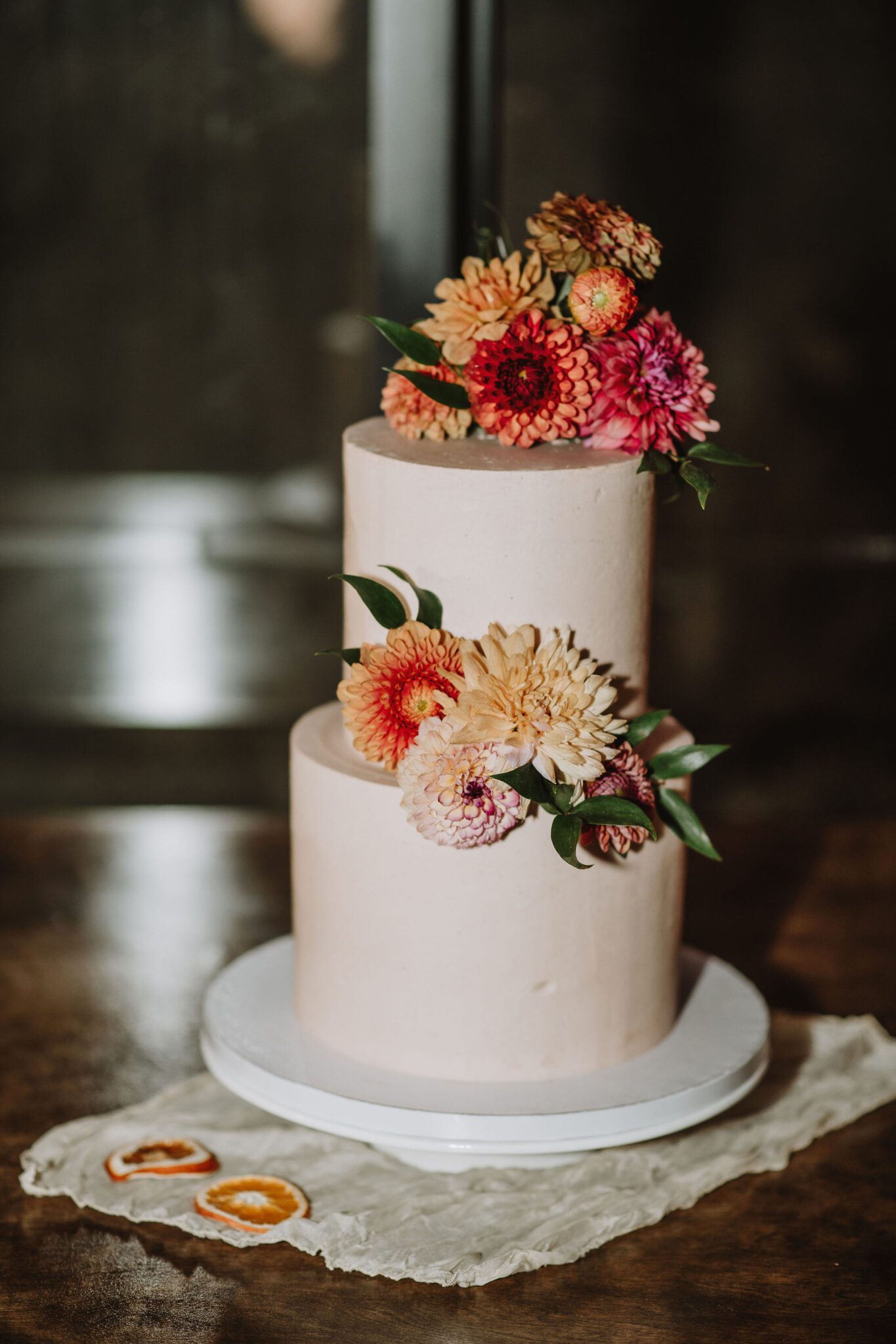 Close up detailed photo of simple wedding cake with colourful florals.