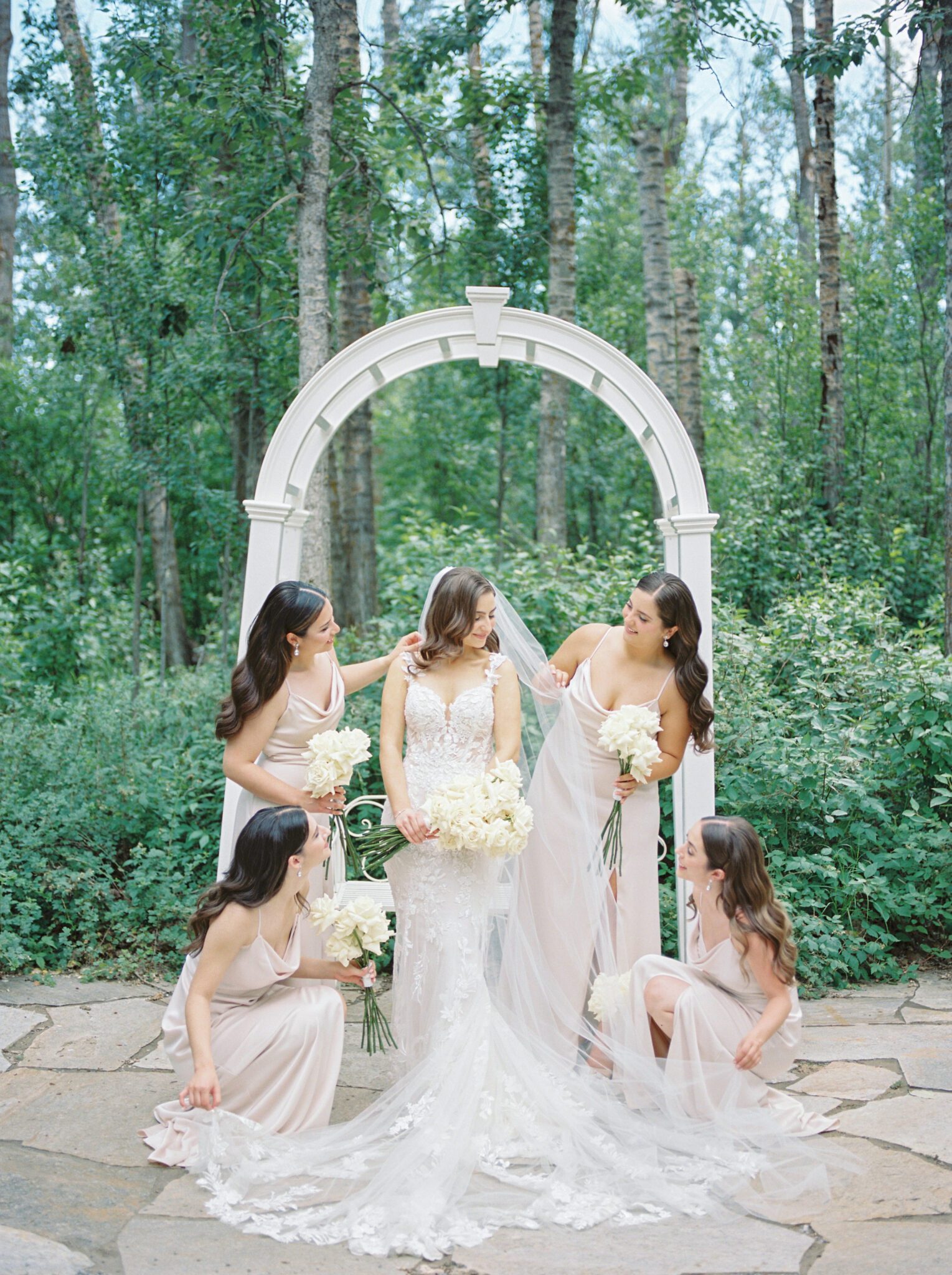 Elegant wedding at Sparrow Lane Events in Alberta. Bride surrounded by bridesmaids. Classic colour palette of white, blush, and green wedding inspiration.
