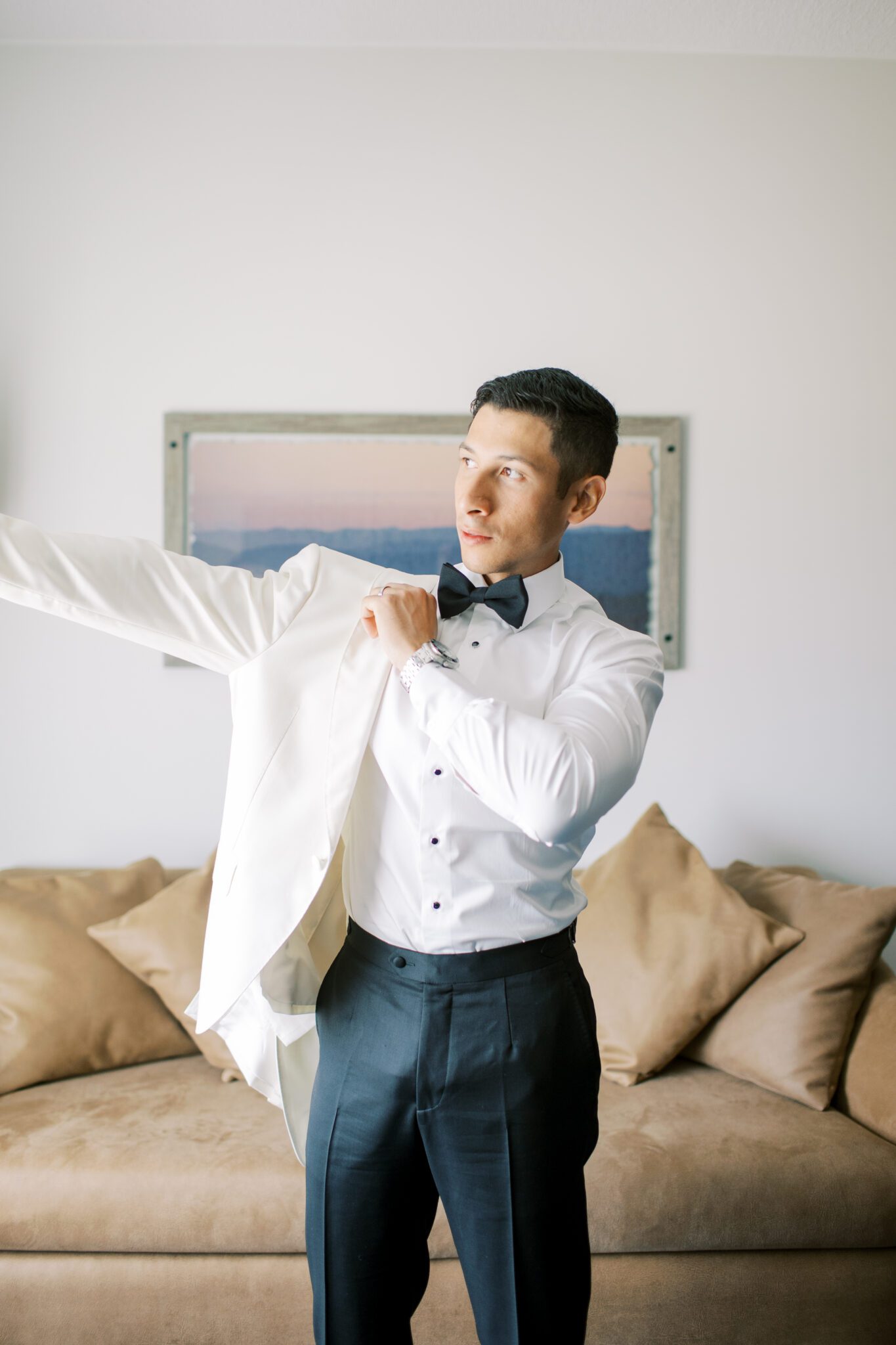 Groom getting ready on his wedding day at Sparrowlane Events. Elegant wedding inspiration. Classy white tux jacket and black pants by Atelier Suiting.