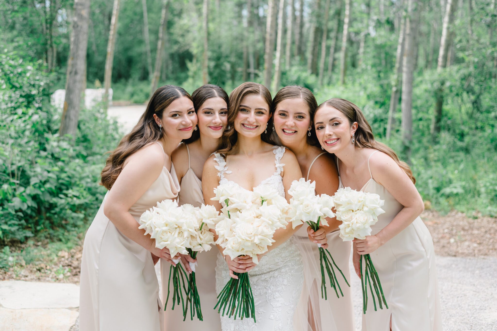 Elegant wedding at Sparrow Lane Events in Alberta. Bride surrounded by bridesmaids. Classic colour palette of white, blush, and green wedding inspiration. Timeless Summer Wedding.