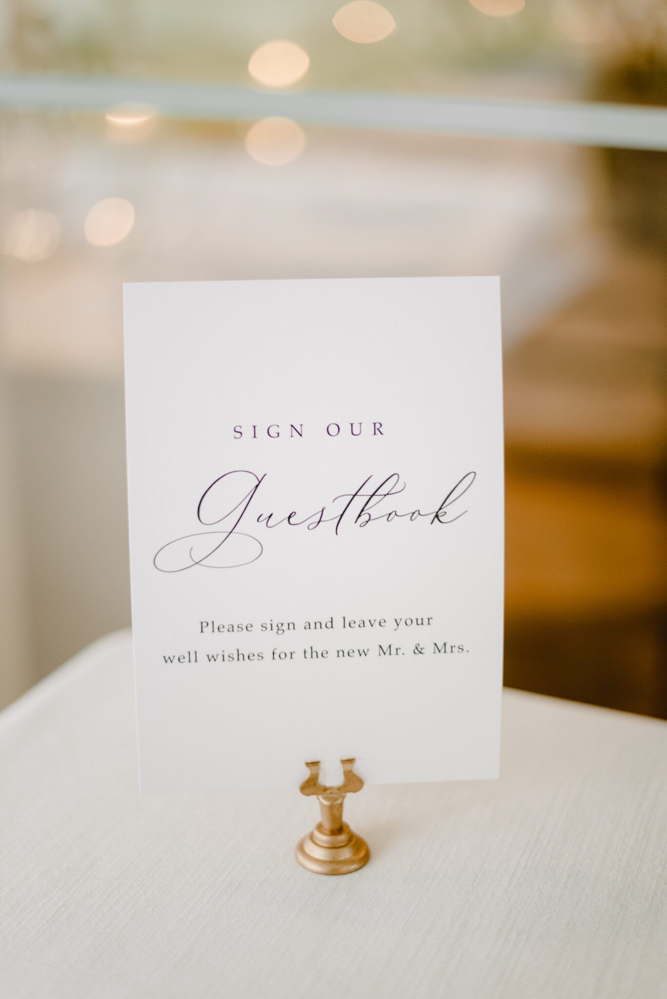 White and gold wedding reception guestbook sign. Elegant summer wedding reception at Sparrow Lane Events in Alberta. Summer wedding features white roses, greenery blush decor accents and warm wood tones.