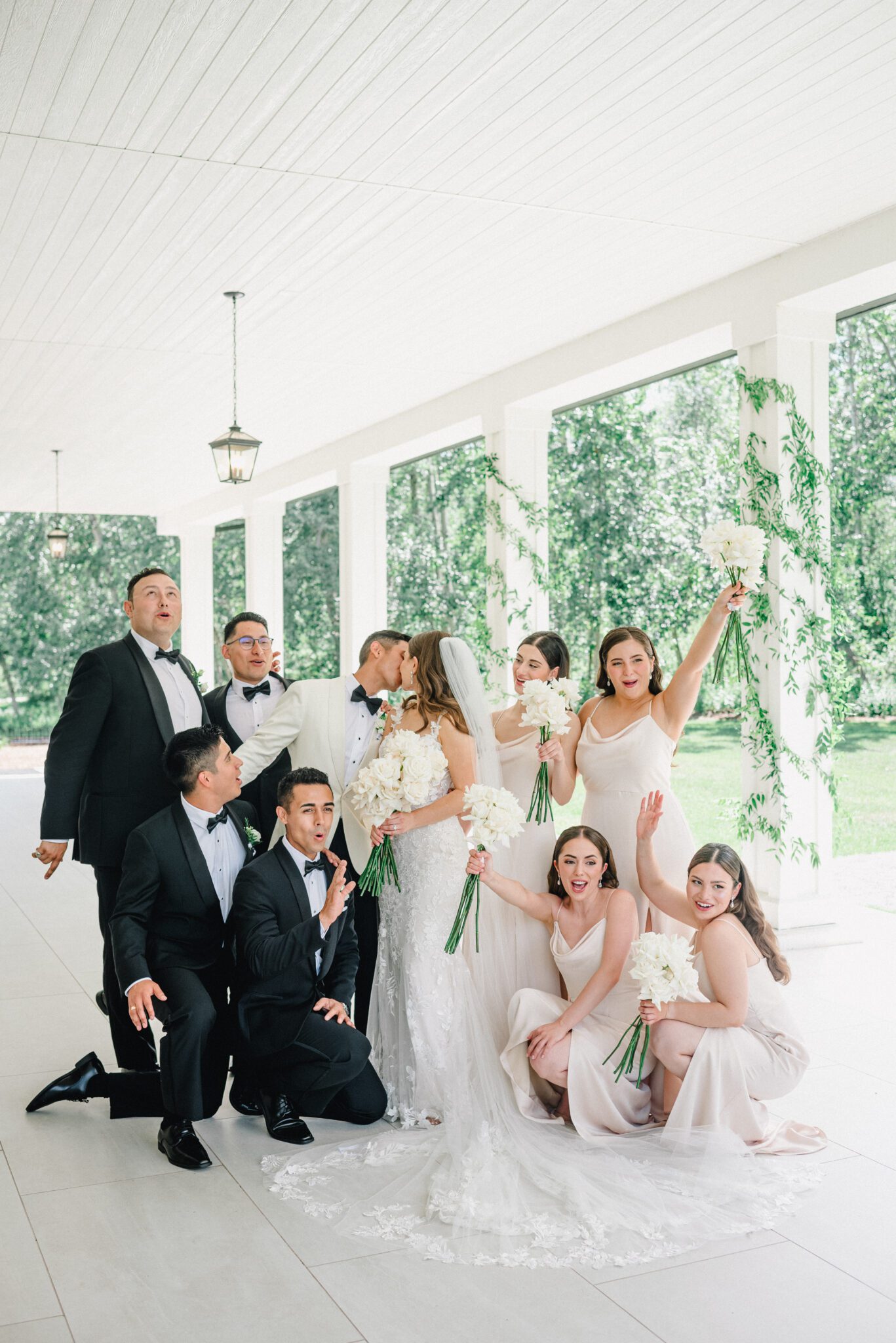 Elegant wedding party outside of Sparrow Lane Events in Alberta. Classic colour palette of white, blush, and green wedding inspiration.