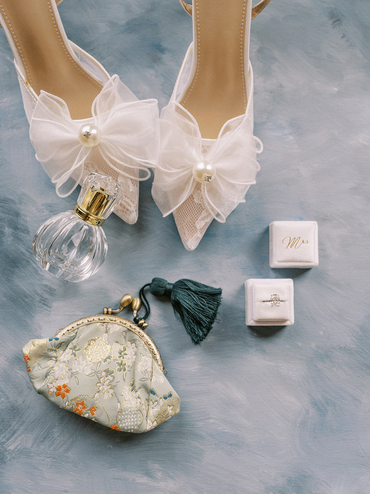 Elegant bridal details featuring lace heels with pearl and bow detailing, “Mrs” ring box and mediterranean inspired clutch captured by Justine Milton.