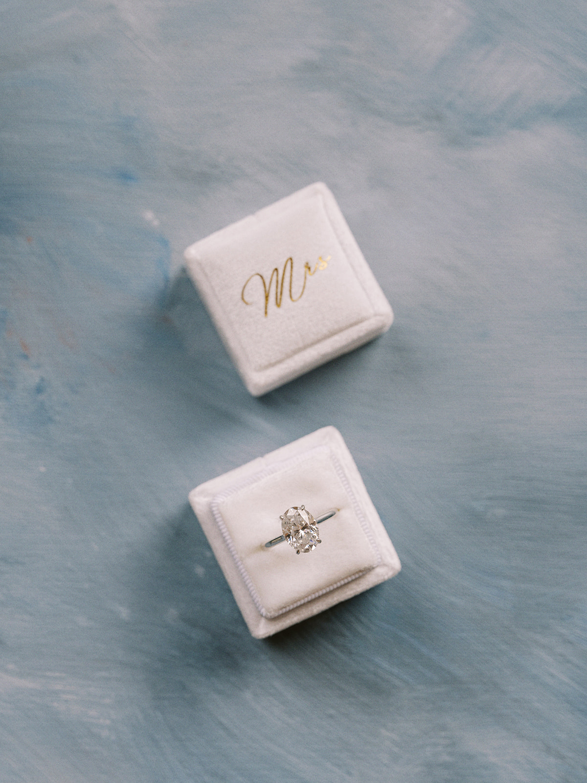 Elegant wedding ring box with gold “Mrs.” lettering captured by Justine Milton.