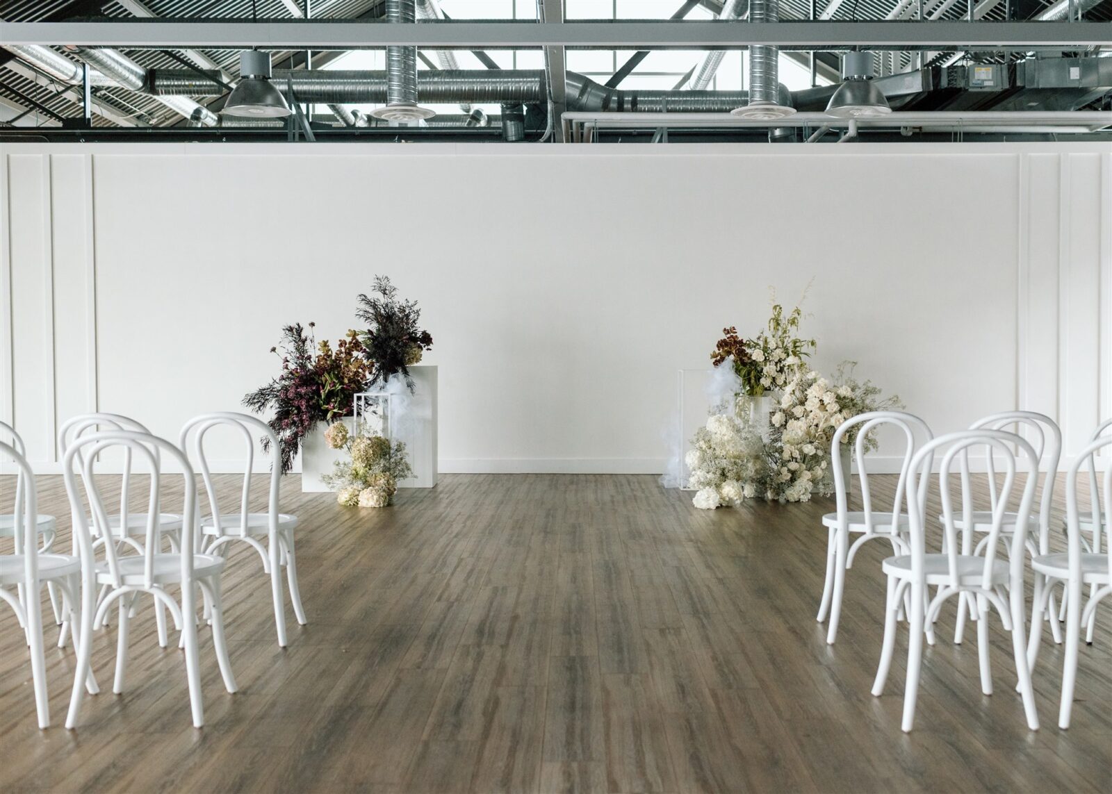 Chic and minimalist wedding ceremony at The Wallace Venue in Vancouver, BC. Featuring stunning plum and white florals by Celsia Florals.