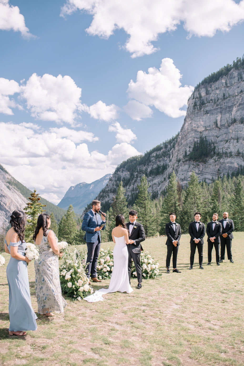 Bride and groom exchange vows during sophisticated mountain wedding in Banff, Alberta, Canada. Summer mountain wedding inspiration. 