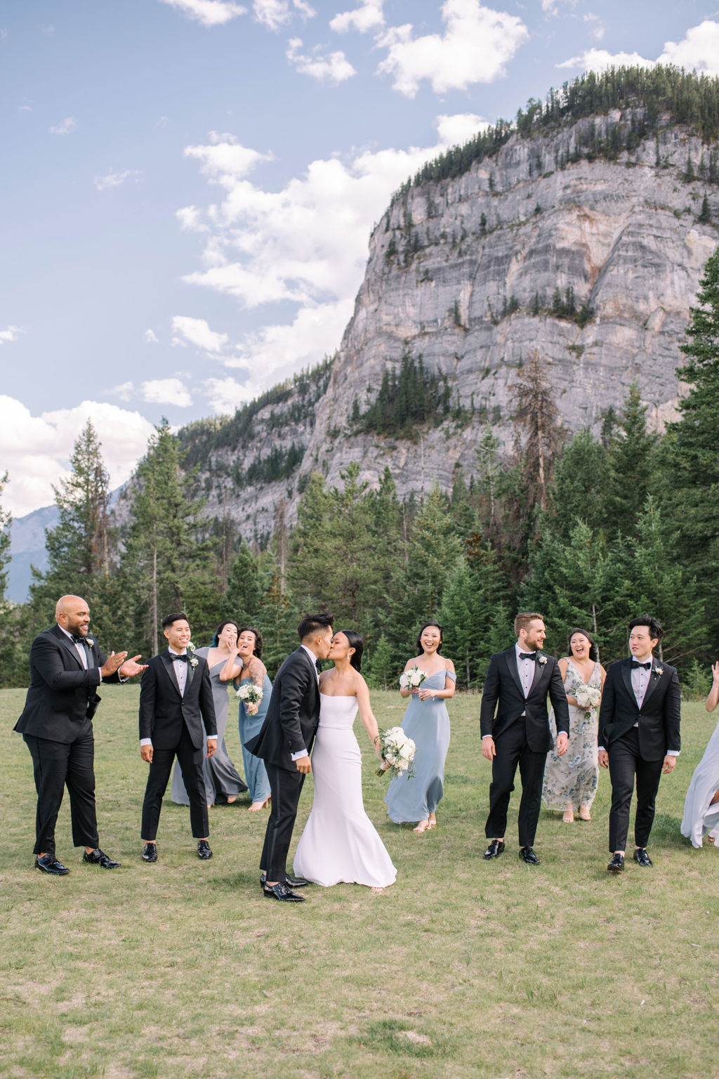 Wedding party walking together in the mountains of Banff, Alberta, Canada. Elegant summer wedding inspiration, Classic neutral, blush, cremes, dusty blue colour scheme, white rose bouquets.