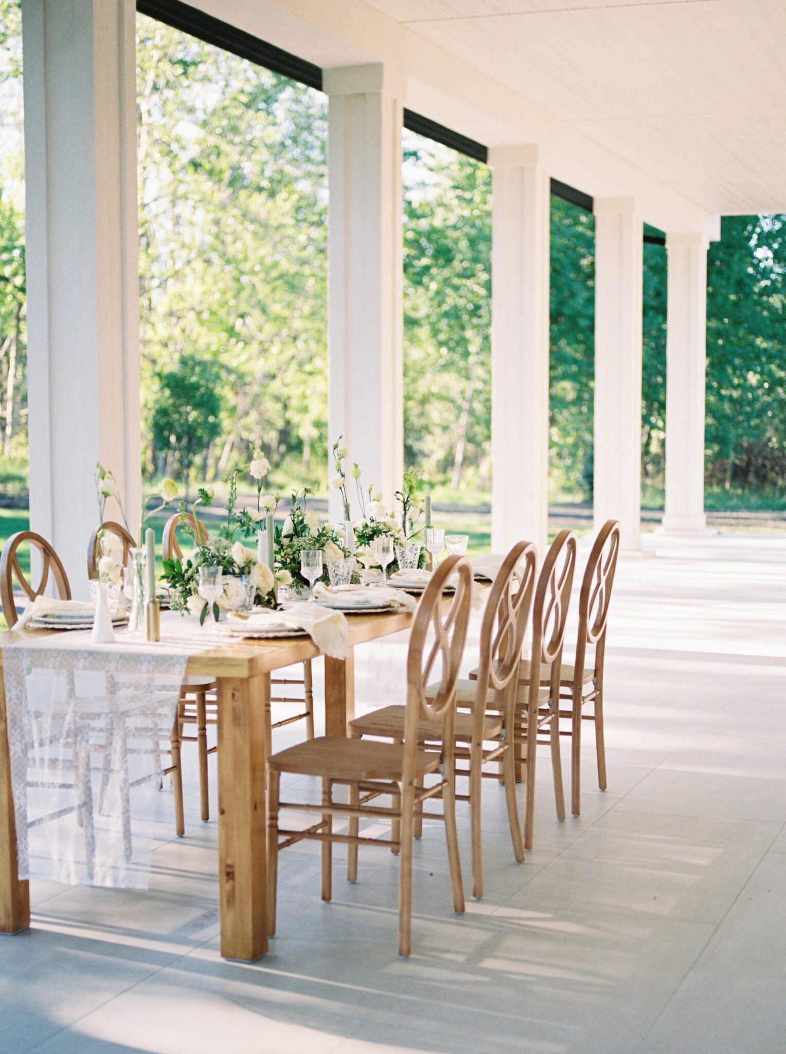 Cottage core inspired wedding reception at Sparrow Lane Weddings and Events venue near Edmonton, Alberta. Fine art summer wedding. Wooden infinity chairs, outdoor summer wedding tablescape with lush florals in pale yellow, ivory and white with greenery. 