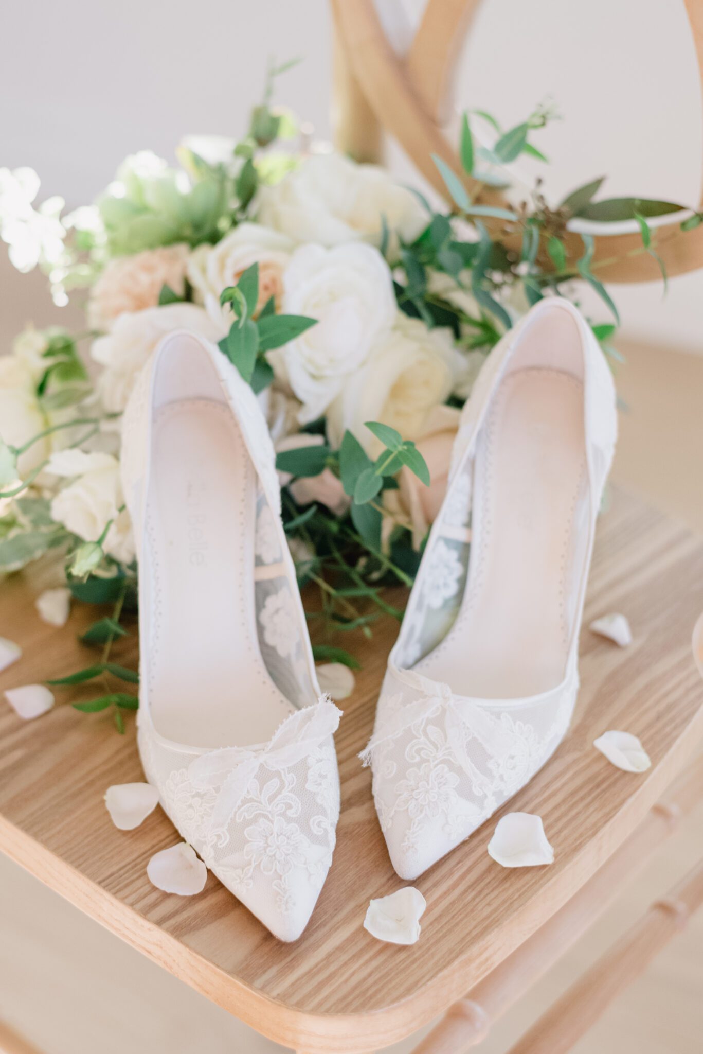 Sophisticated cottage core inspired bridal details. Lace bridal shoes by Bella Belle Shoes, styled with lush pale yellow, ivory, white, and green florals.