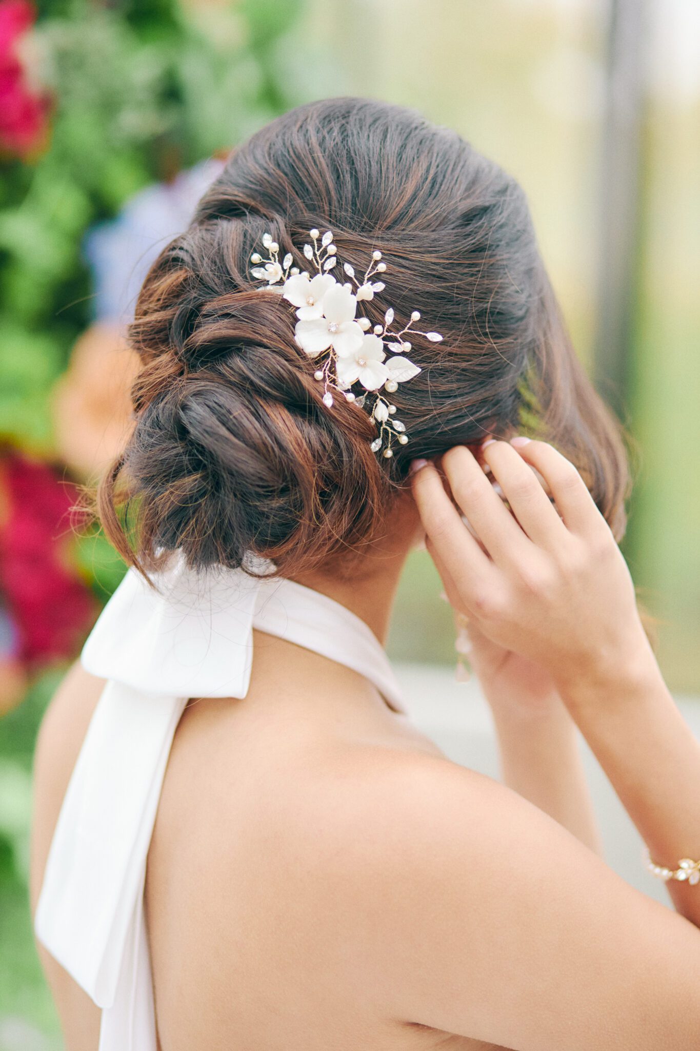 Elegant and modern bride wears a backless wedding dress, pearl hairpiece, and statement earrings by Joanna Bisley Designs.