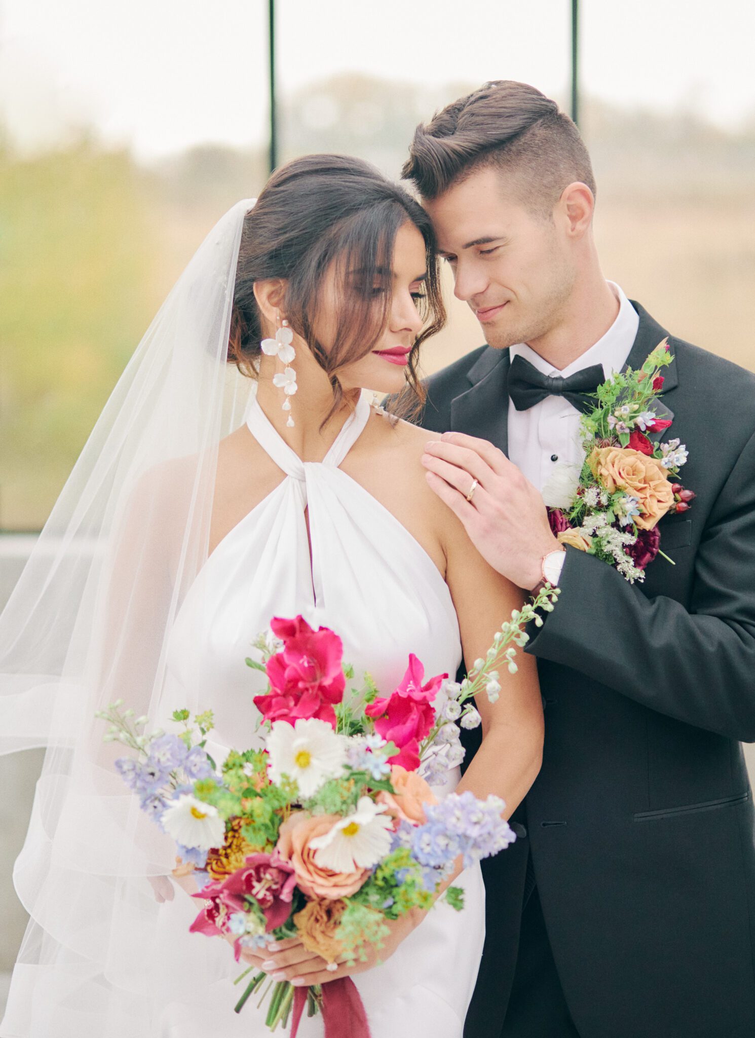 Elegant and modern bride wears a halter style wedding dress, and bold pink lipstick. Bridal fashion inspiration. 