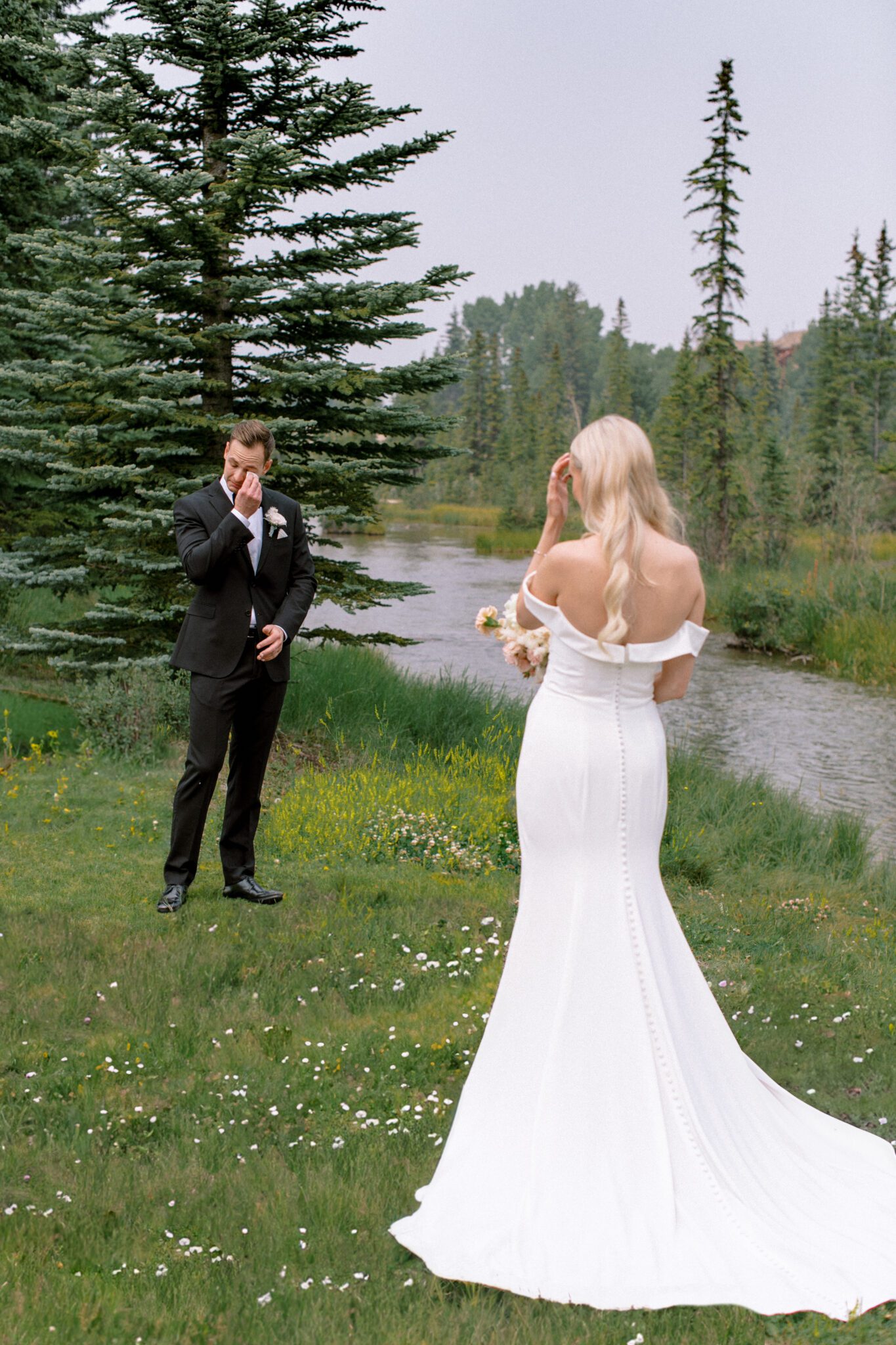 Bride and groom first look at Stewart Creek Golf Course in Canmore, Alberta. Wedding first look inspiration. Groom's reaction to seeing bride for the first time. 