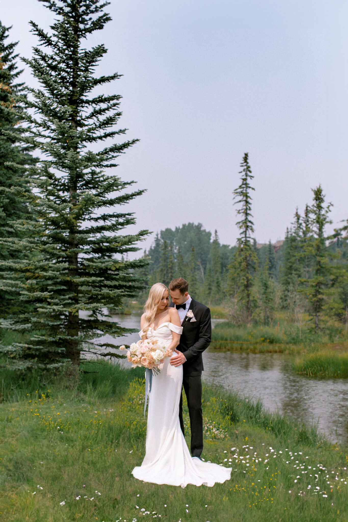 Bride and groom embracing during Steward Creek Golf Course wedding in Canmore, Alberta. Spring wedding inspiration. 