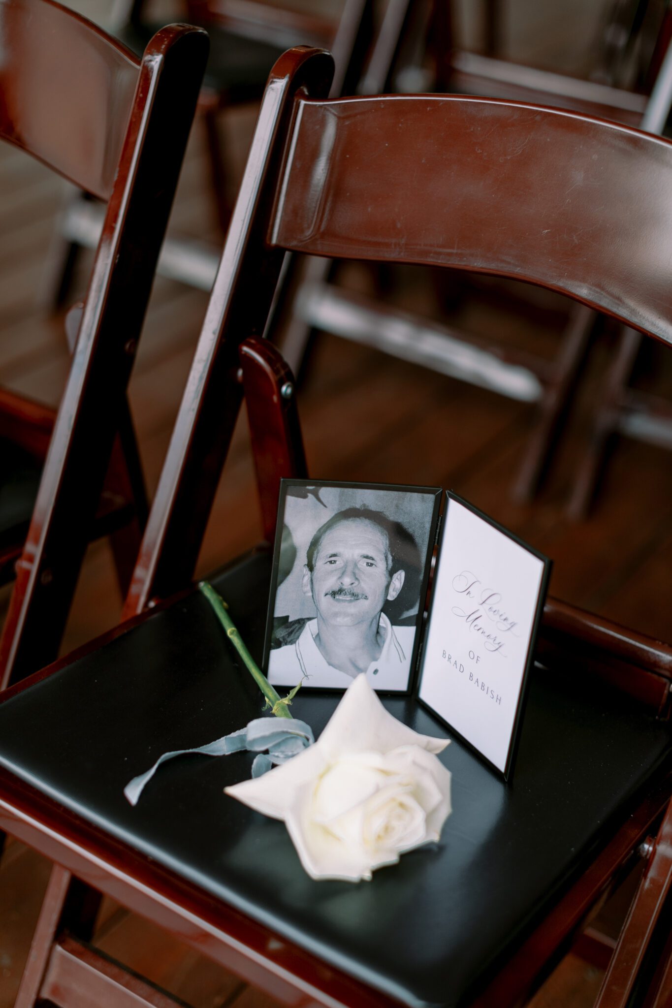 Wedding ceremony setup at Stewart Creek Golf Course in Canmore, Alberta. White, pink and black colour scheme. Mountain wedding ceremony. Wedding ceremony memorial on chair. 