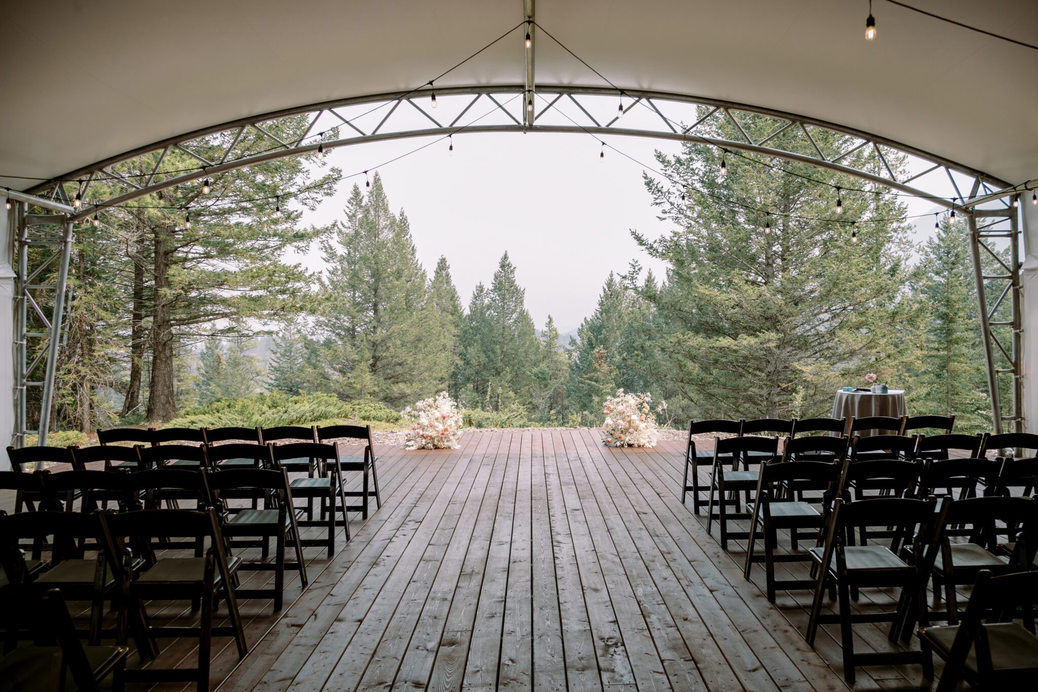 Wedding ceremony setup at Stewart Creek Golf Course in Canmore, Alberta. White, pink and peach colour scheme. Mountain wedding ceremony.