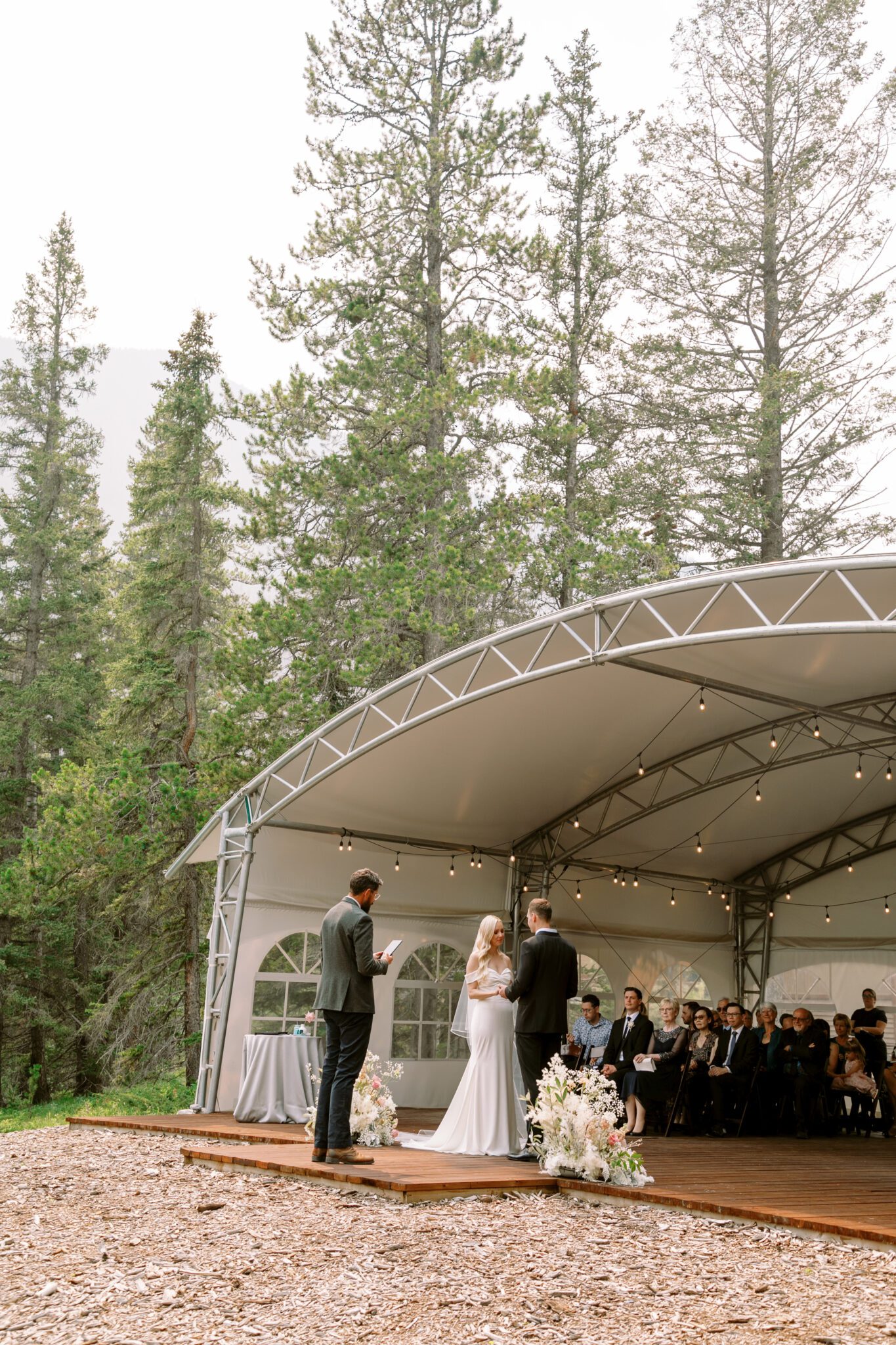 Wedding ceremony setup at Stewart Creek Golf Course in Canmore, Alberta. White, pink and black colour scheme. Mountain wedding ceremony. 