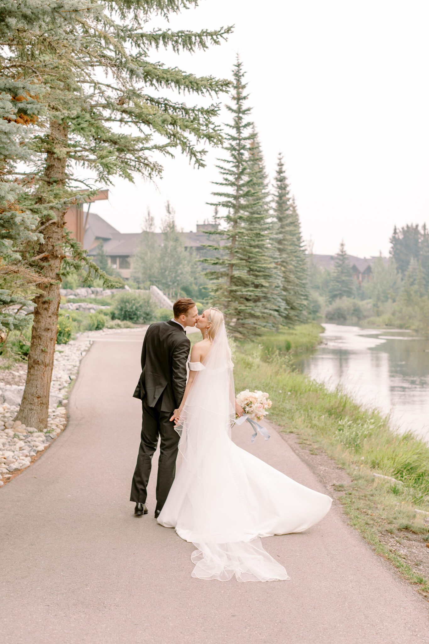 Bride and groom embracing during Steward Creek Golf Course wedding in Canmore, Alberta. Spring wedding inspiration. 