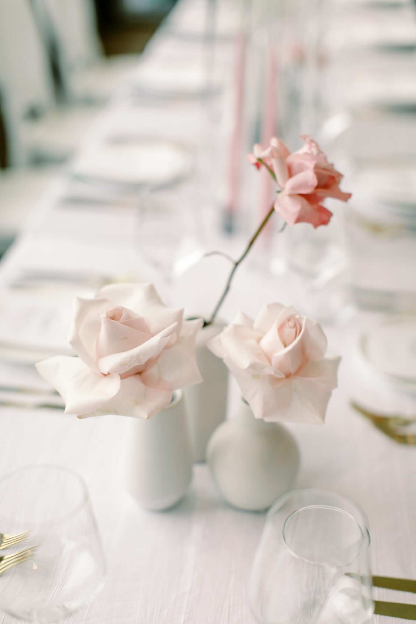 Modern and chic wedding reception at The Sensory in Canmore, Alberta.  Long tables with white linens, blue napkins, and pink floral centrepieces
