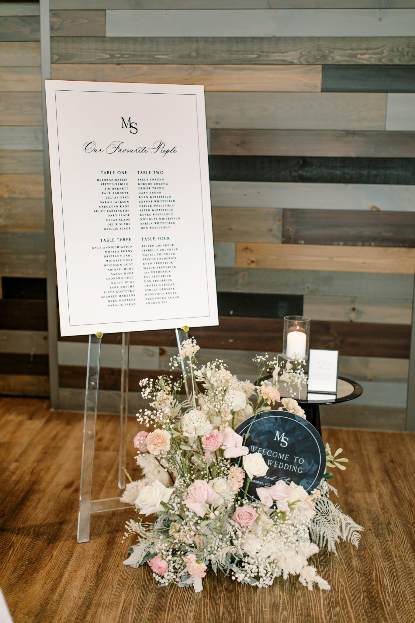 Wedding reception signage at The Sensory in Canmore, Alberta. Black and white wedding signs surrounded by candles and pink and white florals.