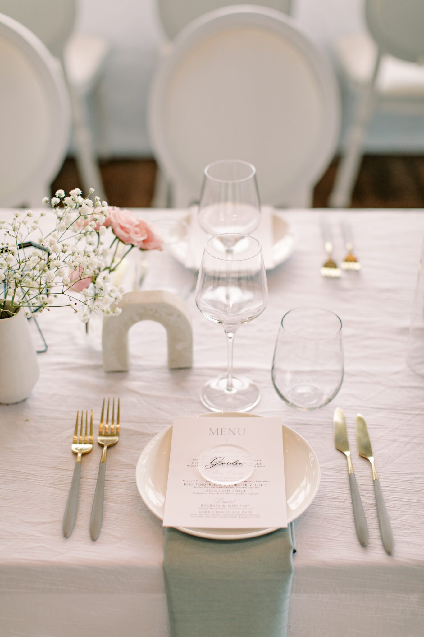 Modern and chic wedding reception at The Sensory in Canmore, Alberta.  Long tables with white linens, blue napkins, and pink floral centrepieces
