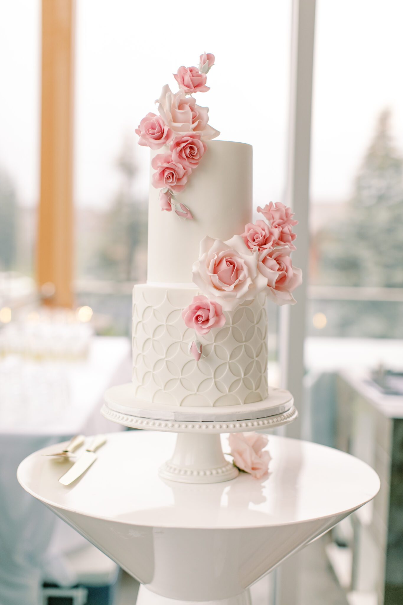 Beautiful 2-tiered white wedding cake with pink sugar roses created by Yvonne's Delightful Cakes.