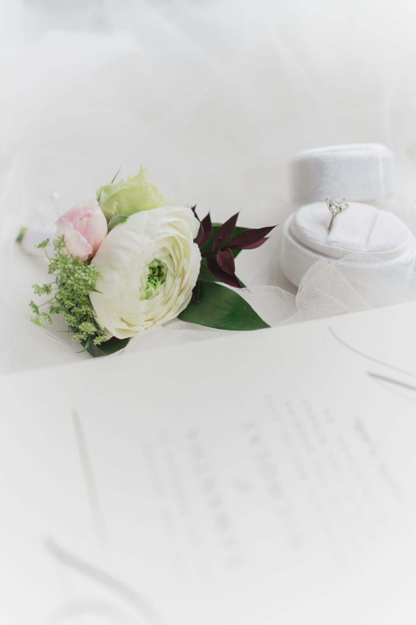 Wedding invitation paper suite featuring classic and elegant white invitation, white velvet ring box, gold perfume bottle, and handcrafted boutonniere by Yours Truly Floral Studio in Chilliwack, British Columbia. 