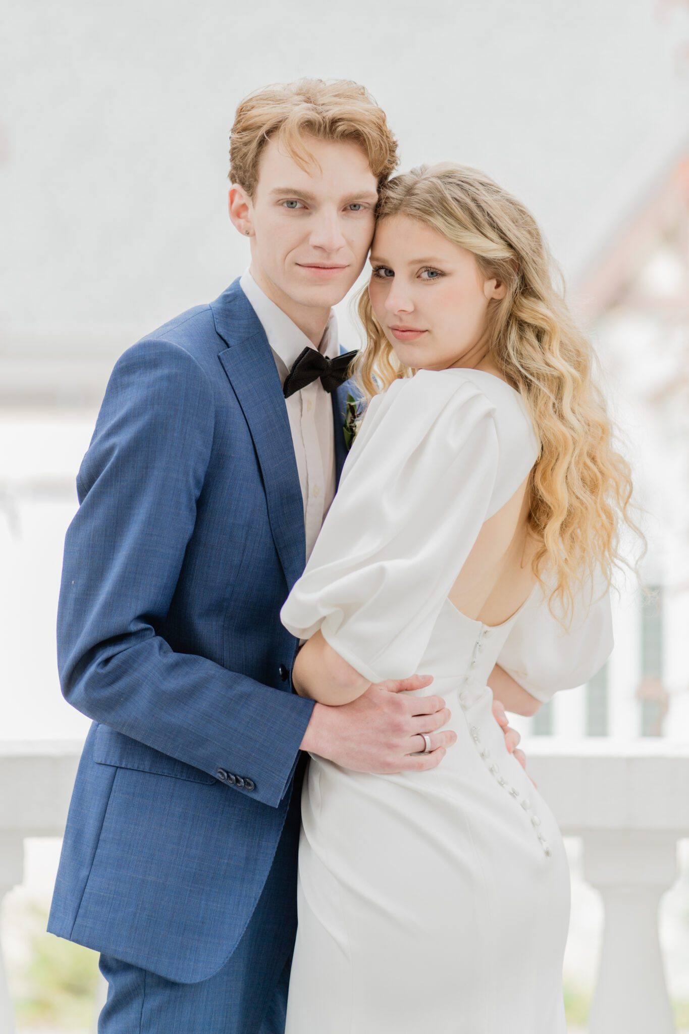 Bride and groom embracing at a timeless elegant wedding at Chilliwack Museum. Featuring the museum's classical architecture featuring pillars, arch windows and a grand staircase.