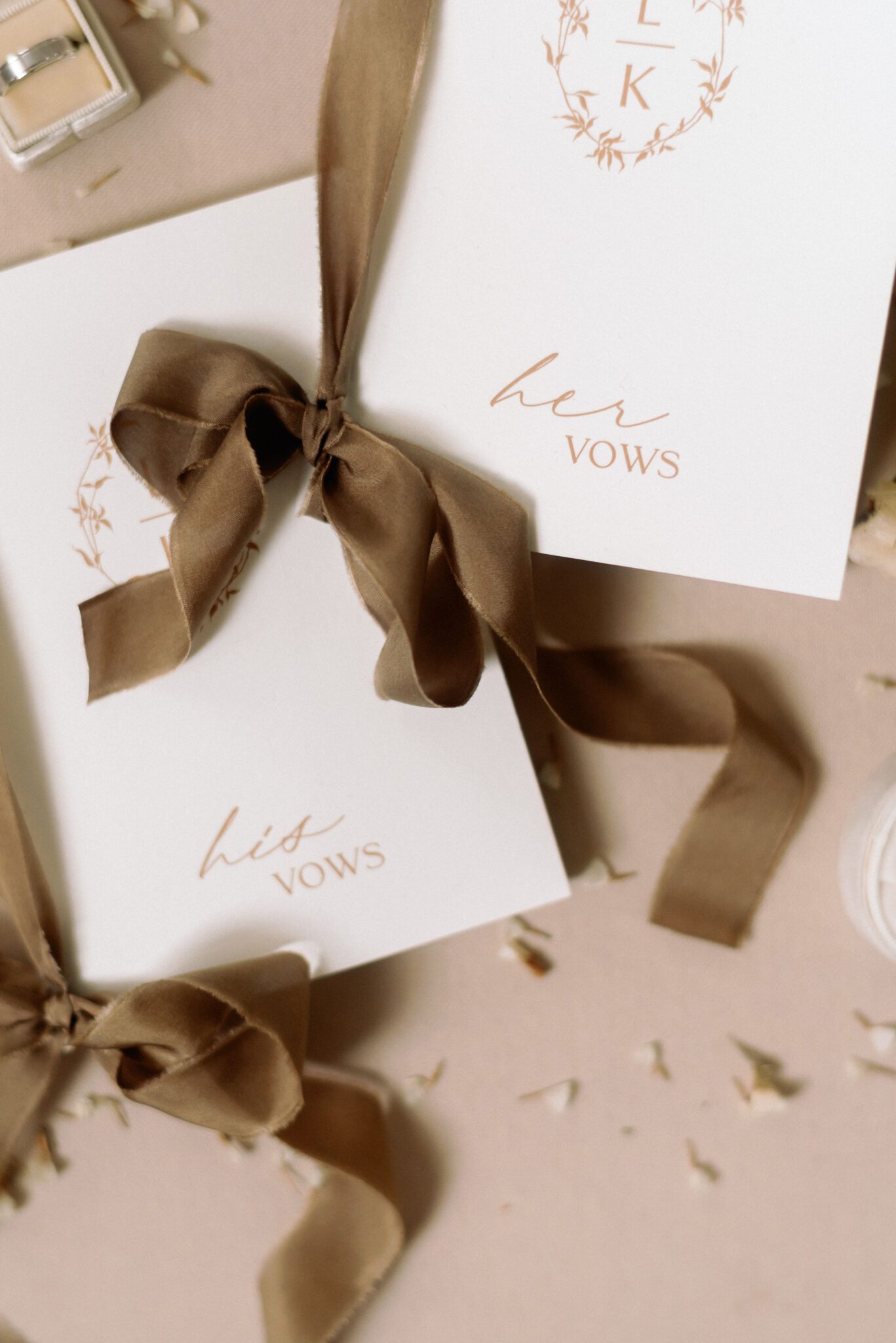 Elegant vow  his and her vow books ties with taupe satin ribbon, surrounded by dried florals.