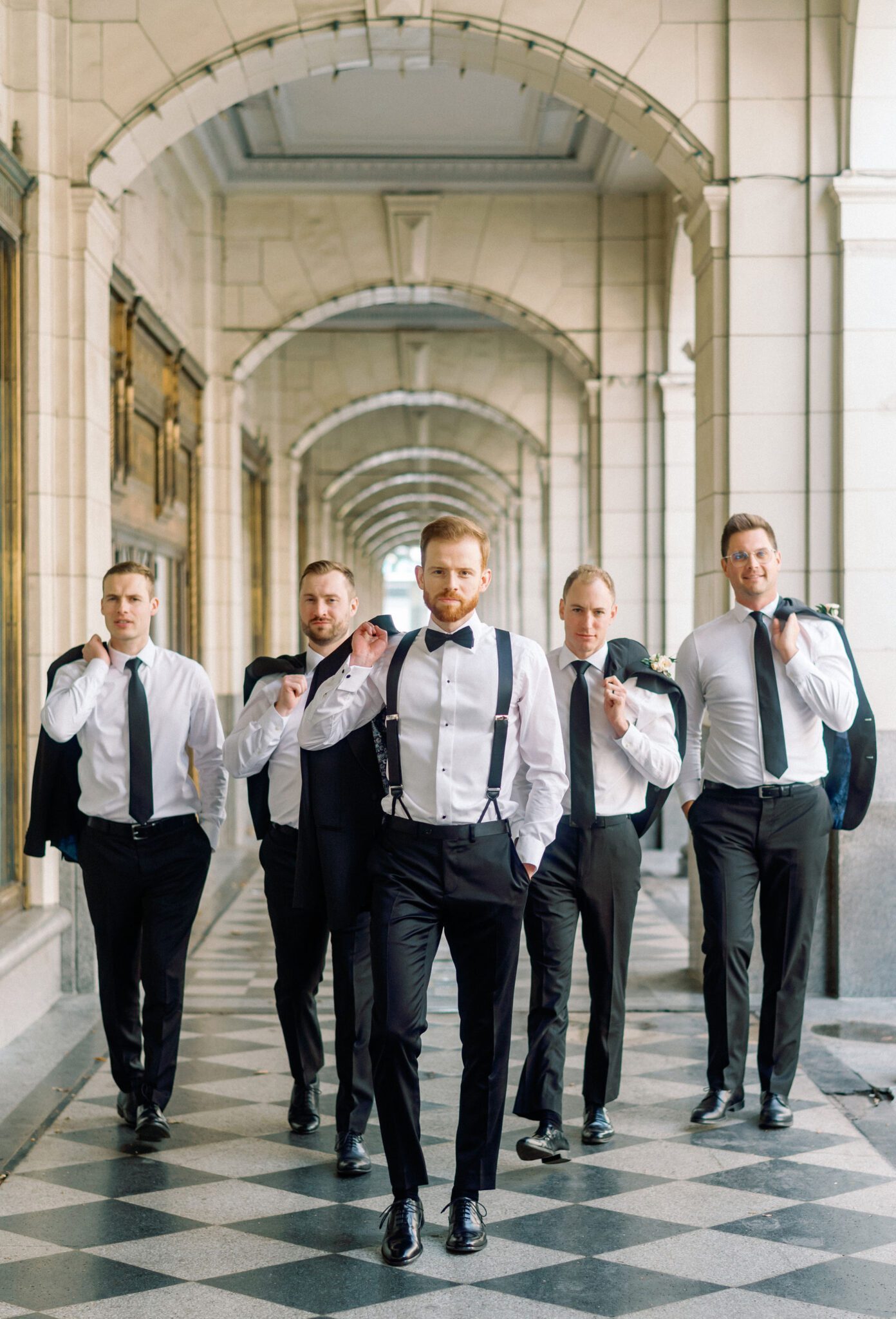 Groom and groomsment walking together outside of Hudson in downtown Calgary, Alberta.