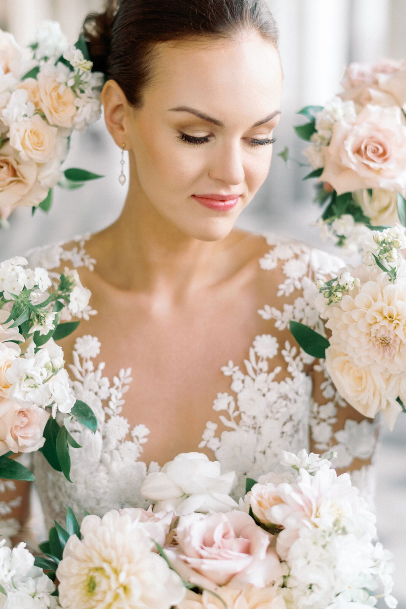 Elegant bride surrounded by elegant floral bouquets.