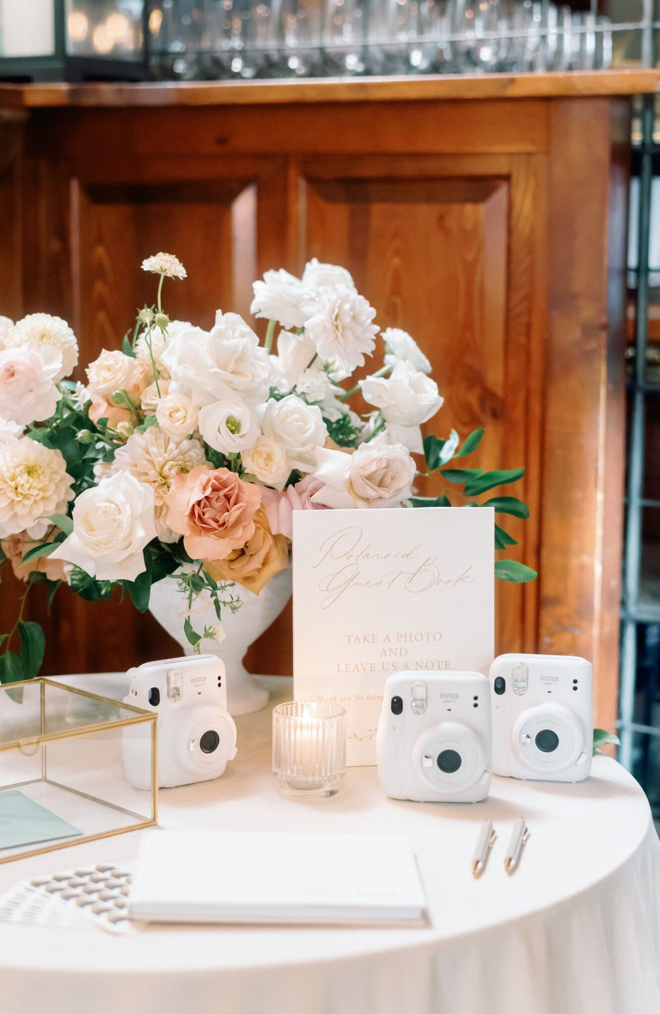 Candlelit Polaroid Guest Book at Bonterra Trattoria surrounded by elegant pink and white roses.