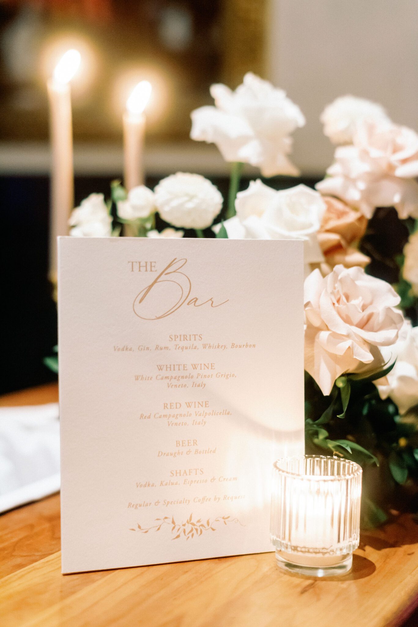 Candlelit bar menu at Bonterra Trattoria surrounded by elegant white roses.