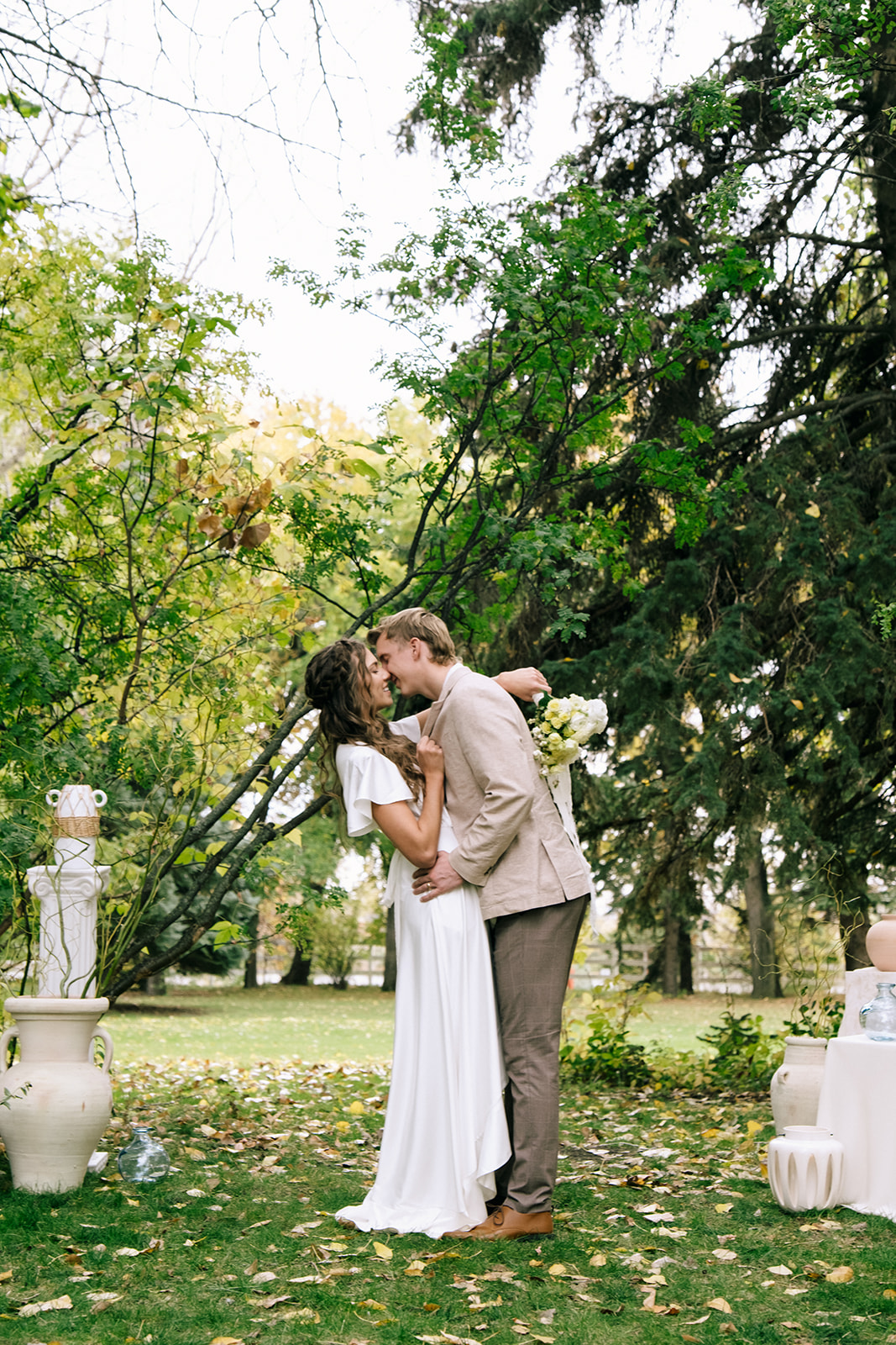 Bride and groom share their first kiss at cottage core inspired wedding ceremony at The Norland Historic Estate in Southern Alberta.