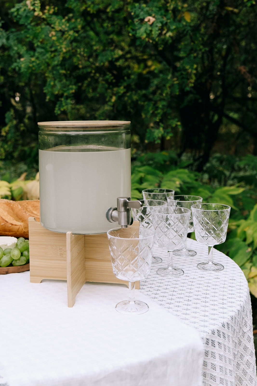 Charming serve-yourself drink station with prosecco, vintage glassware, and a seating chart display.