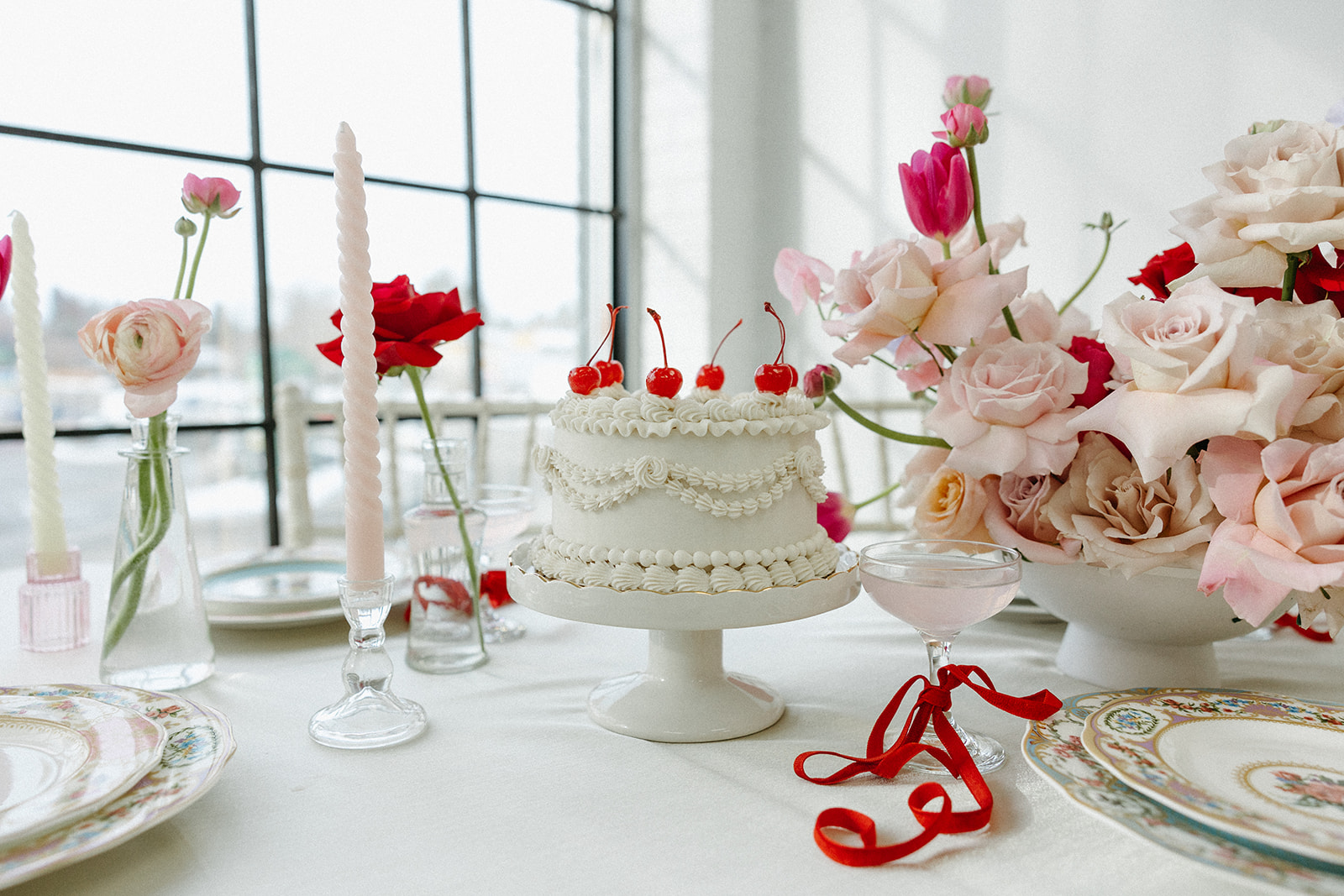 Trendy vintage buttercream wedding cake design with white piped buttercream and cherries on top, perfect for a retro or vintage style wedding.