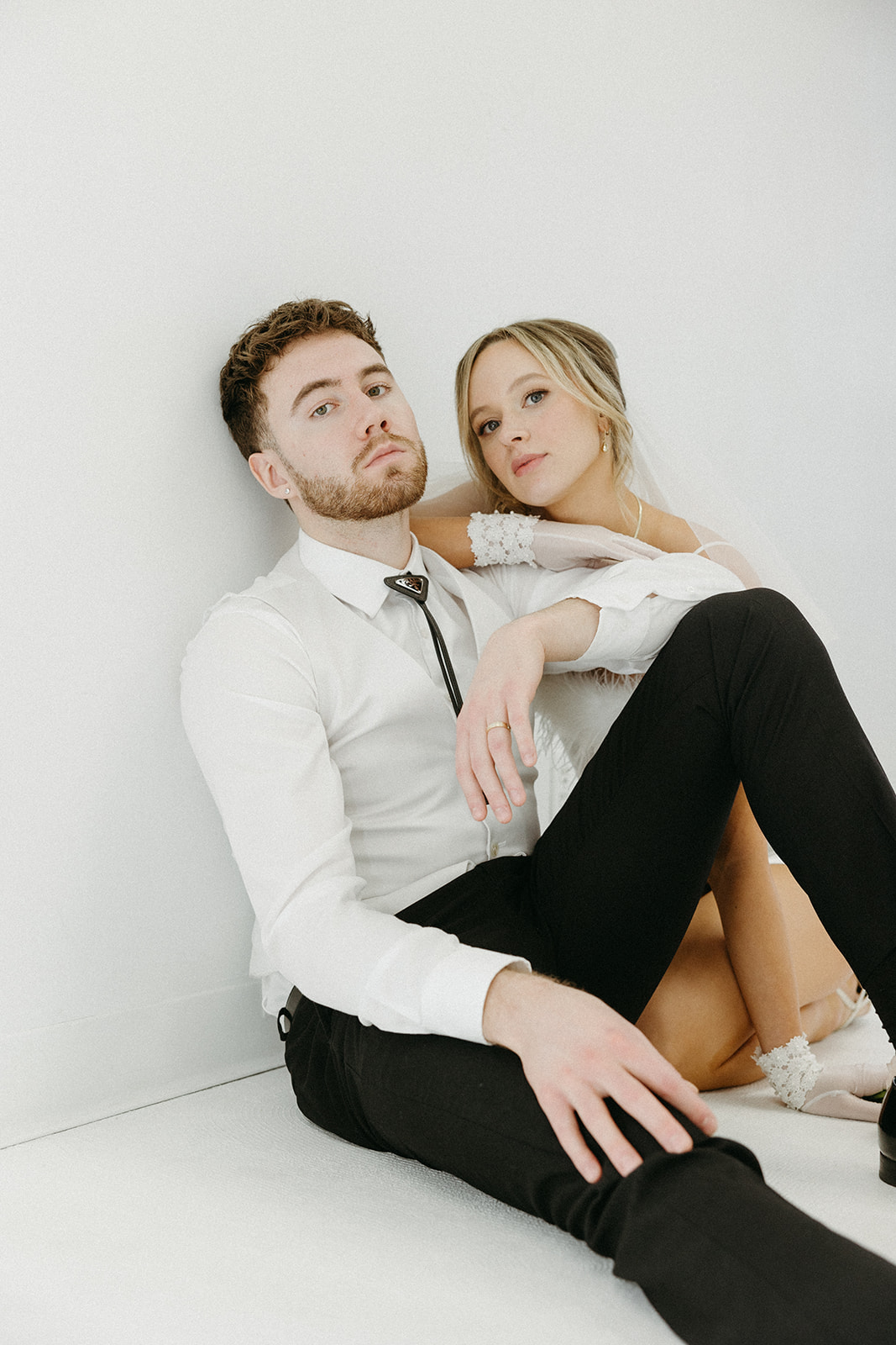 Bride and groom in retro-inspired wedding attire, posed for a funky, creative wedding editorial photoshoot. 
