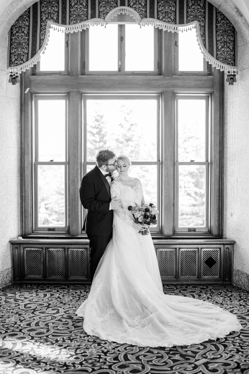 Bride and groom share a quiet moment inside the grand interior of Fairmont Banff Springs, surrounded by elegant architecture and soft candlelight. Wedding Portraits at Fairmont Banff Springs.