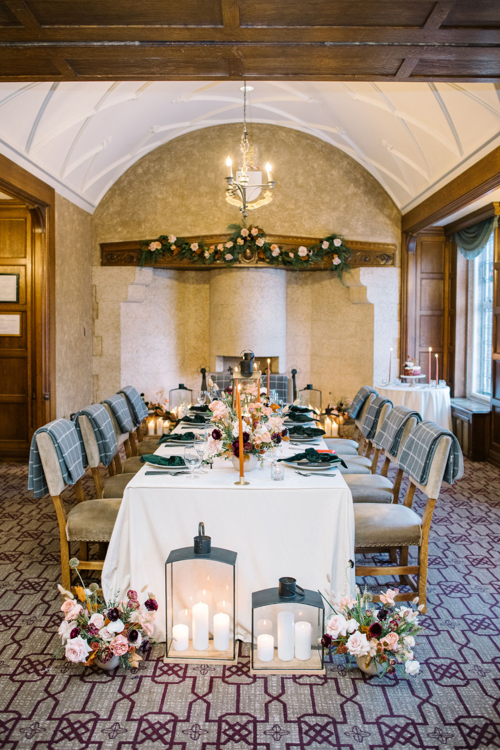 Cozy winter reception in the Angus Room, styled with rich hues and elegant decor for an intimate wedding celebration. Wedding table styled with lanterns, candles, florals and blankets.