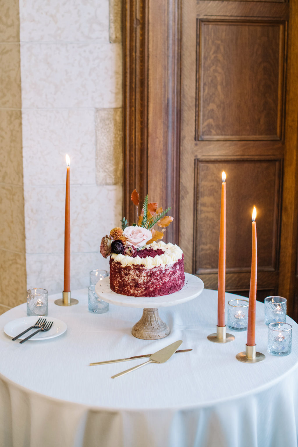 Small burgundy wedding cake. Cozy winter reception in the Angus Room at Fairmont Banff Springs, styled with rich hues and elegant decor for an intimate wedding celebration.