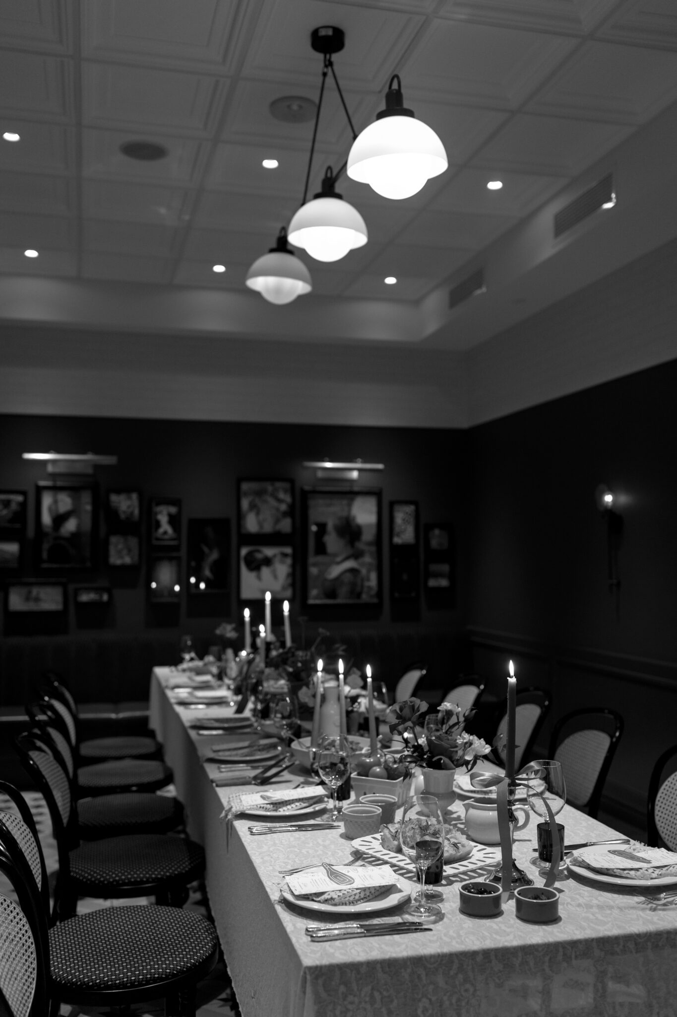 This Italy inspired wedding inspiration at Buffo Restaurant in Calgary, showcases modern sophistication, vintage charm, and a vibrant red colour palette. This photo shows the reception table with food being eat and centerpiece details. #weddingtable #modernweddinginspiration #restaurantreception #vintageweddinginspo