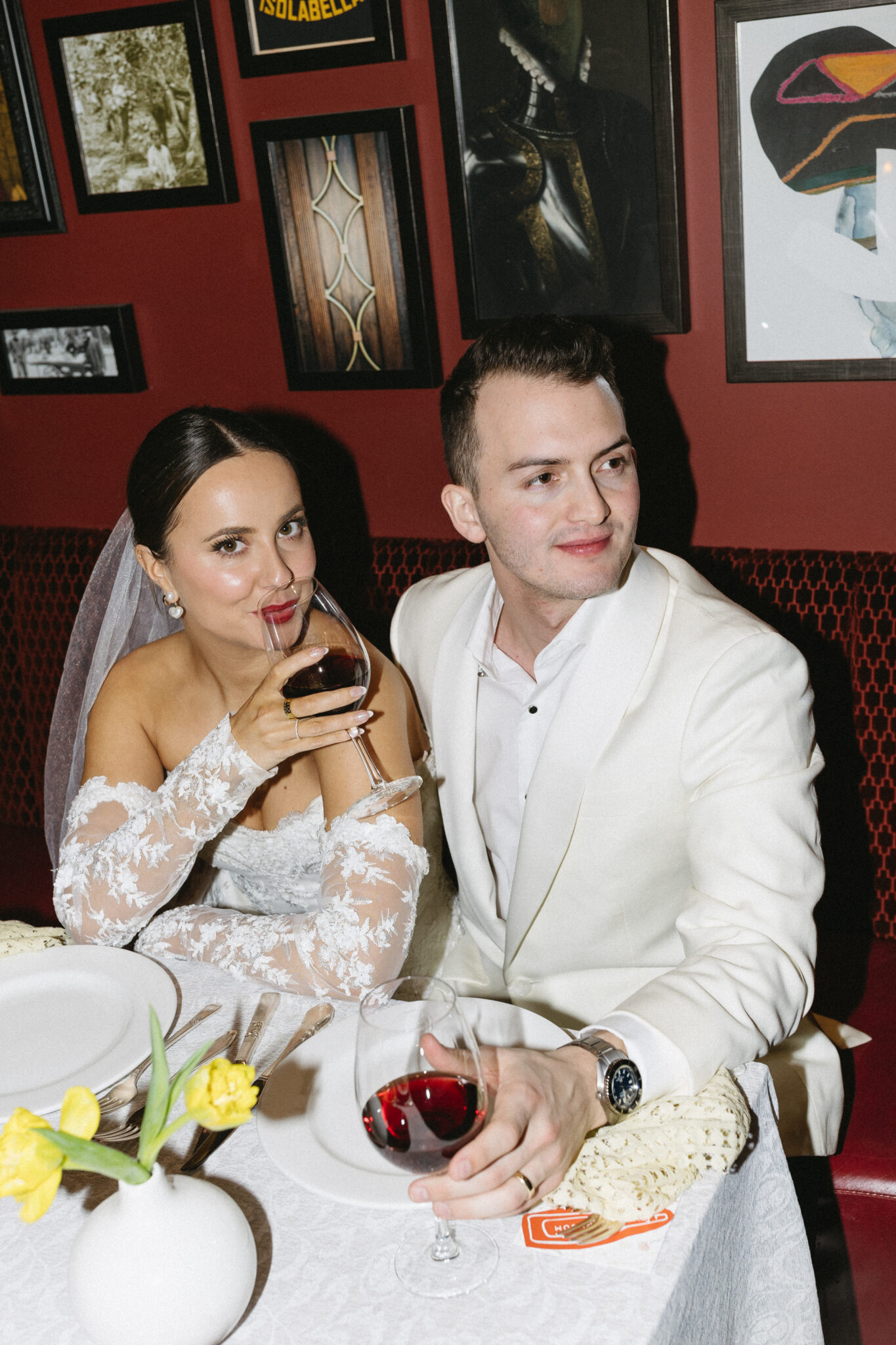 This retro meets modern wedding inspiration in Calgary, showcases modern sophistication, vintage charm, retro details, and a vibrant red colour palette. #brideandgroomattire #lacebridalgown #redrosebouquet #modernweddinginspiration #restaurantreception