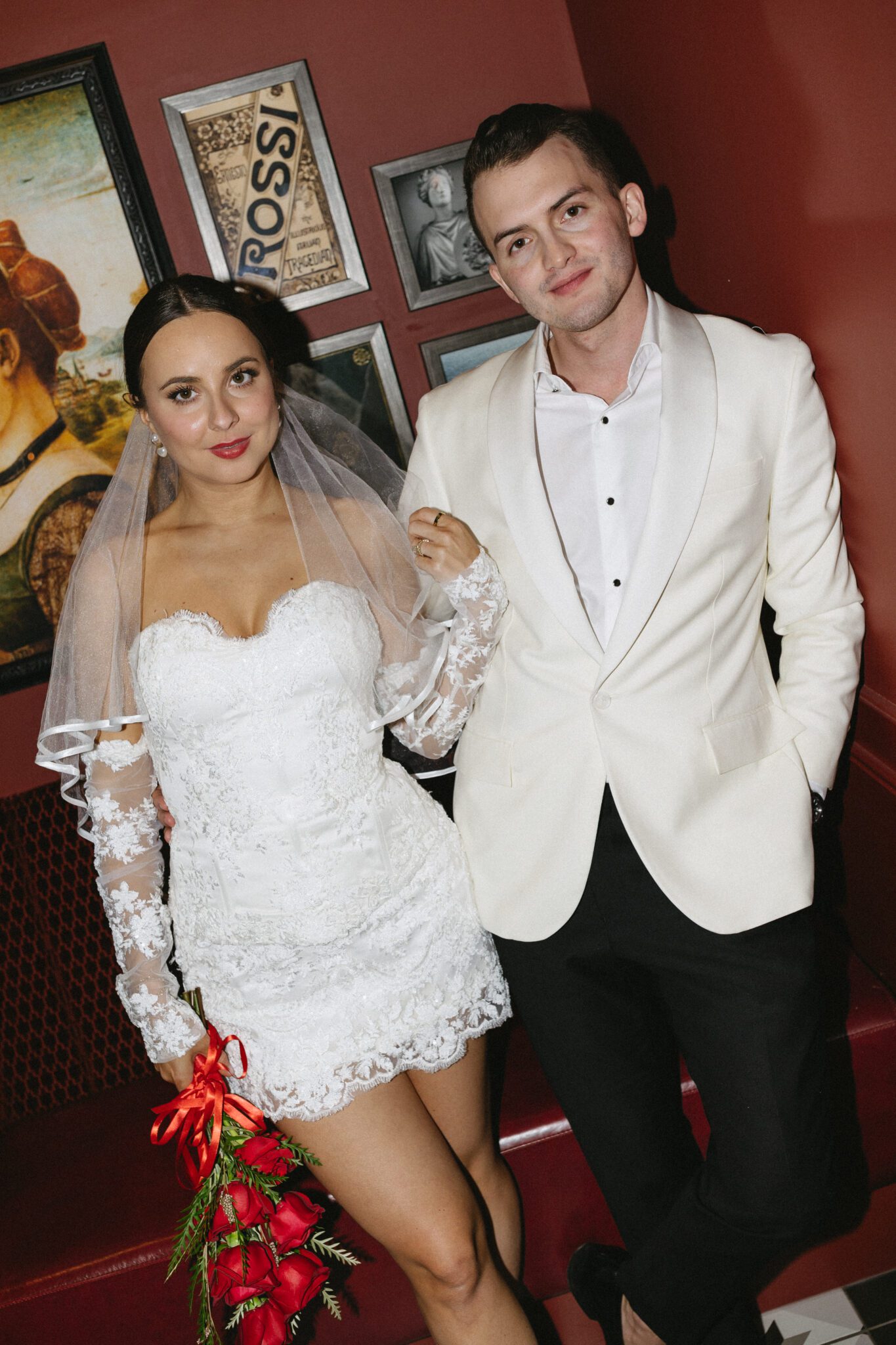 This retro meets modern wedding inspiration in Calgary, showcases modern sophistication, vintage charm, retro details, and a vibrant red colour palette. #brideandgroomattire #lacebridalgown #redrosebouquet #modernweddinginspiration #restaurantreception