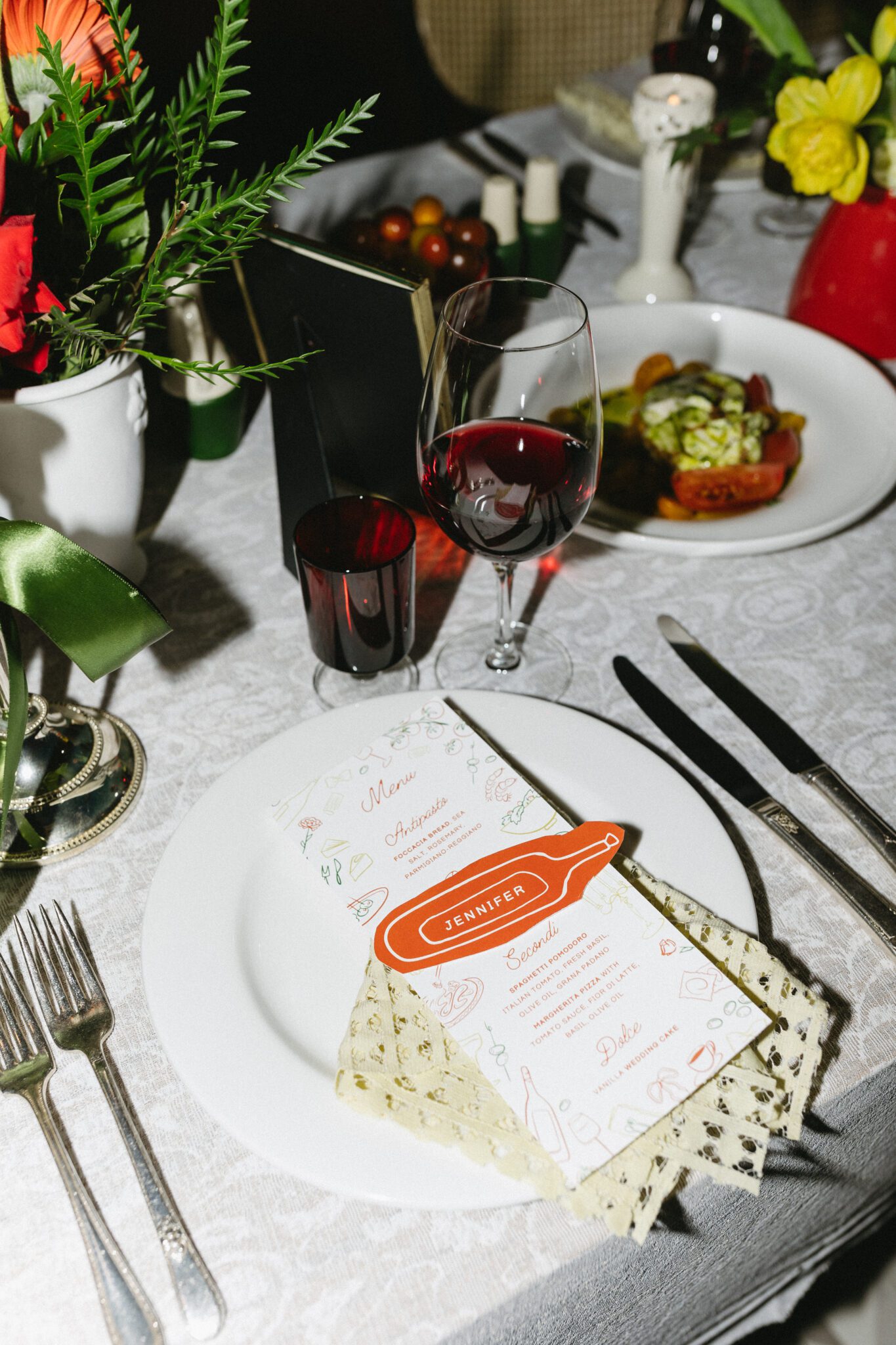 Italy inspired wedding reception table with a colour palette of red, green, yellow and white. Retro meets modern style with european design influence. Tablesettings, menus and placecards, table numbers, floral centerpieces and food. #retroweddinginspiration #restaurantreception #vintageweddinginspo #weddingtable #italyinspiredwedding