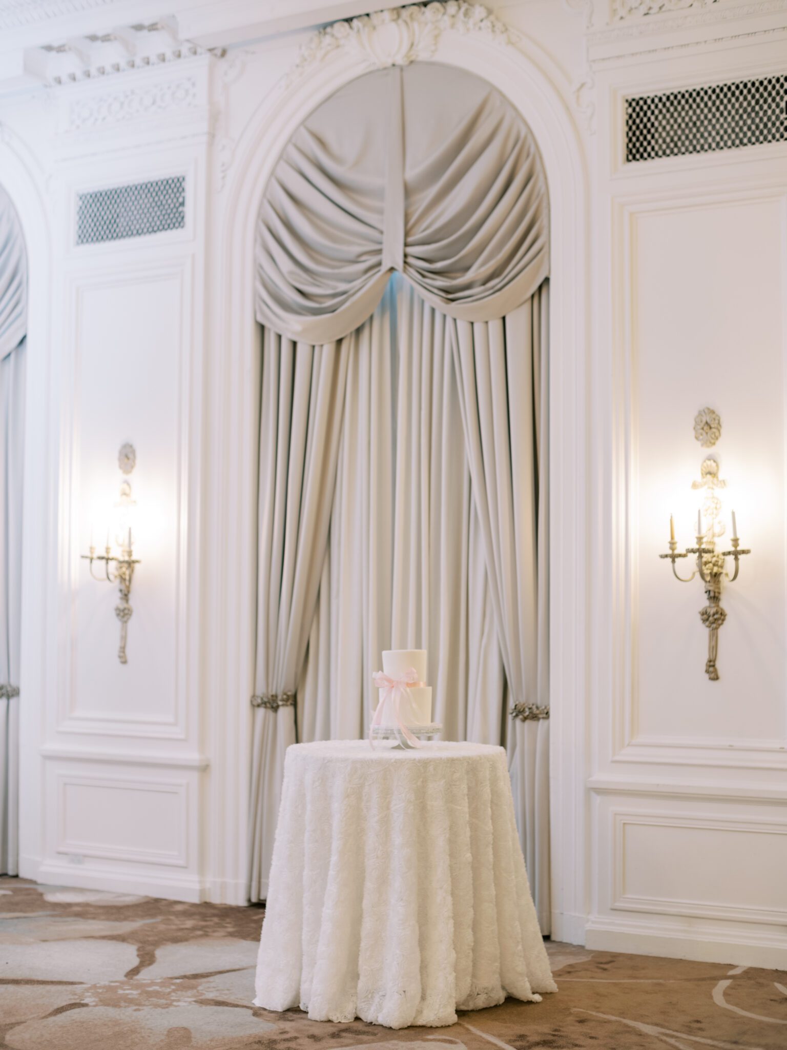 Whimsical ballet blush pink wedding inspiration at Fairmont Palliser Hotel. White wedding cake with pink bow inside the Crystal Ballroom.