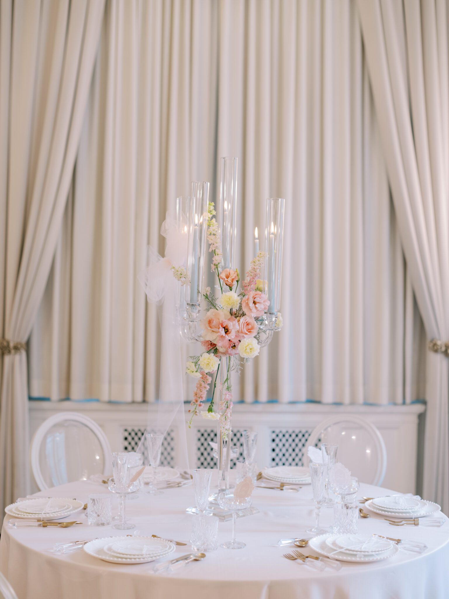 Round blush pink wedding table with crystal candelabra and pale blue candles. Floral centerpiece with Blush roses and pale yellow carnations. Whimsical ballet blush pink wedding inspiration at Fairmont Palliser Hotel. 